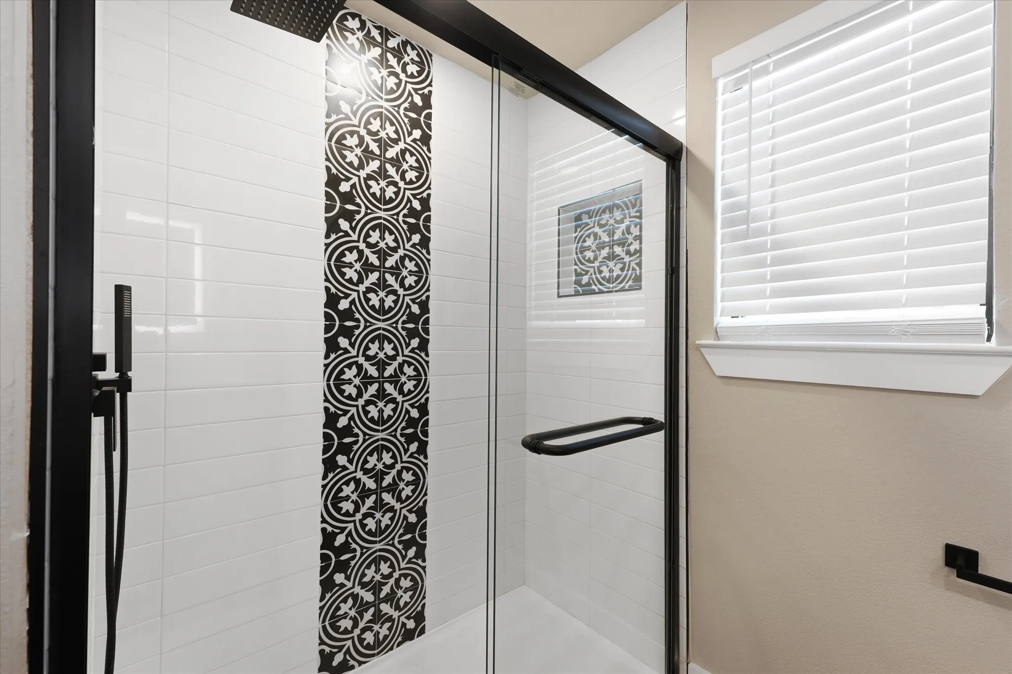 Glass-enclosed shower featuring a matte black frame and hardware