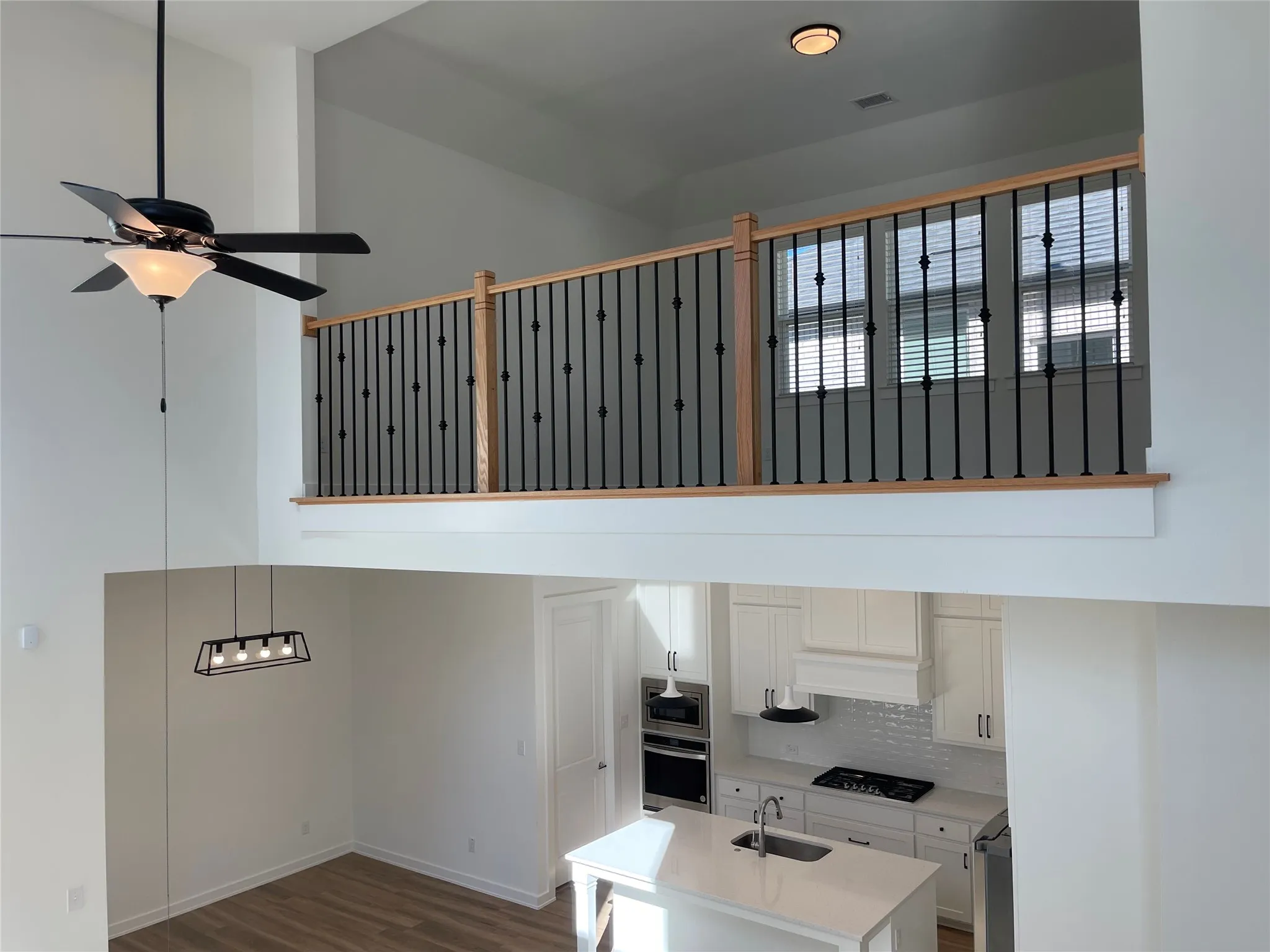 Upper-level overlook with oak handrail and black iron balusters