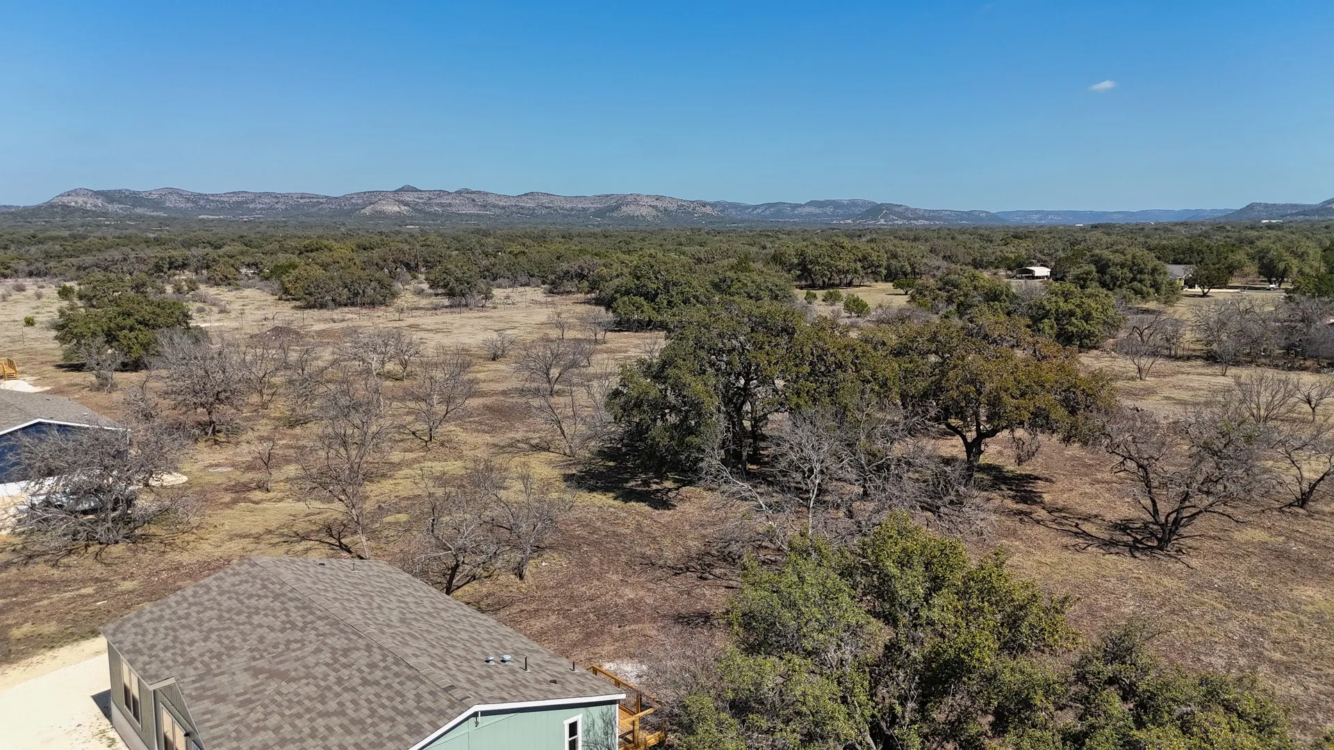 Extensive natural landscape with varied tree coverage and distant hills