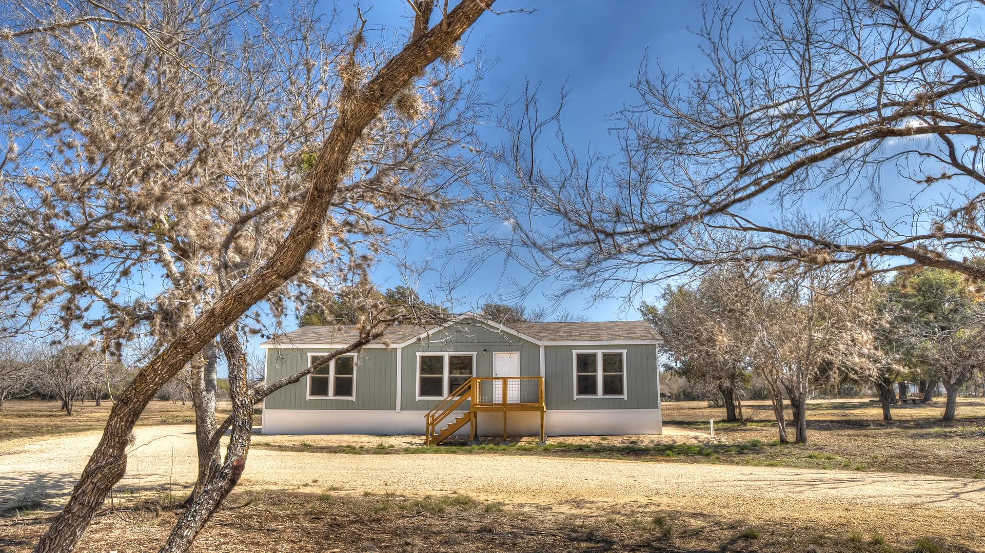 Single-story residential structure with light blue siding and white trim