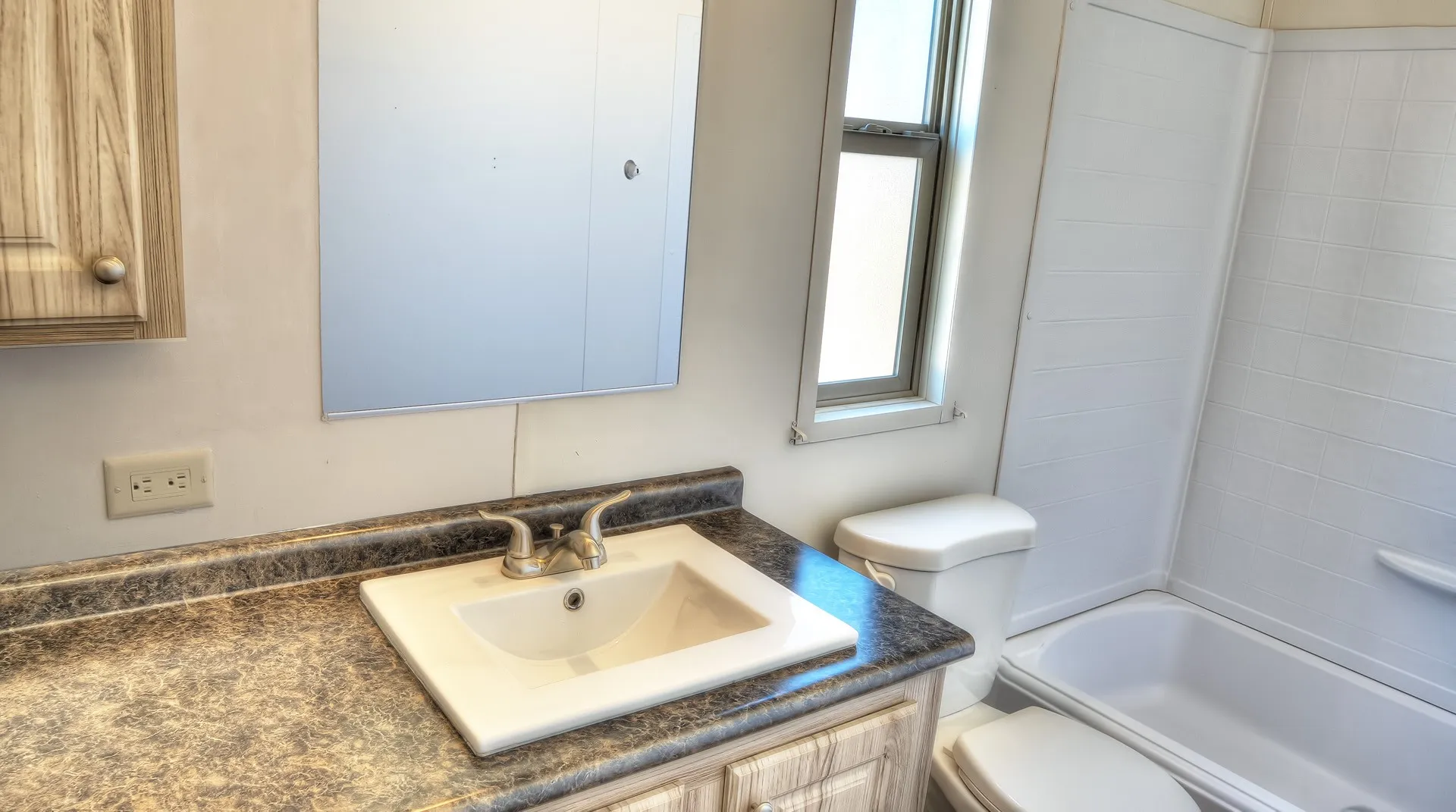 Bathroom featuring a vanity with a laminate countertop, an integrated sink, and a mirrored medicine cabinet
