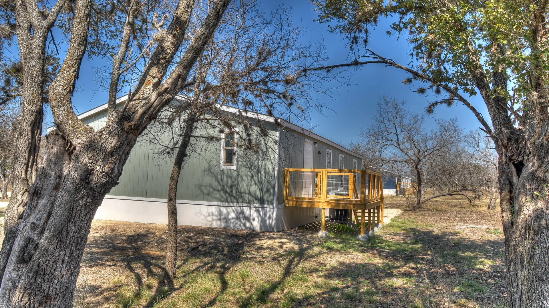Exterior siding in a soft green hue with white trim accents