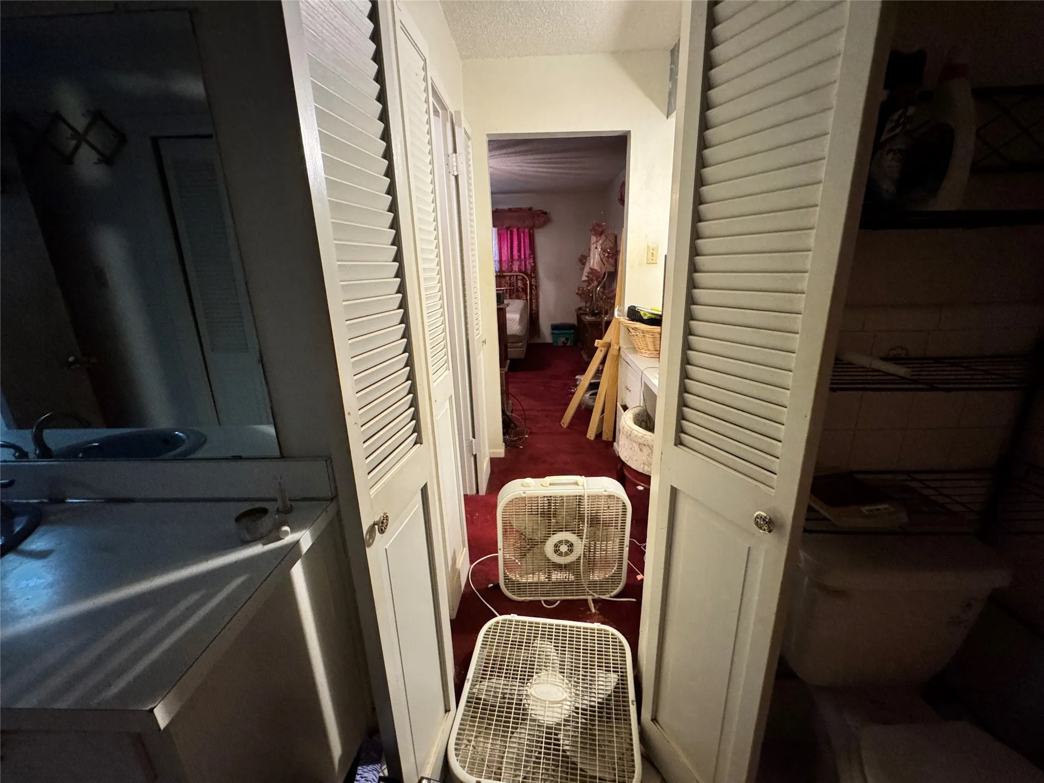 Vanity and walk in closet off of hallway bathroom and toward bedroom.