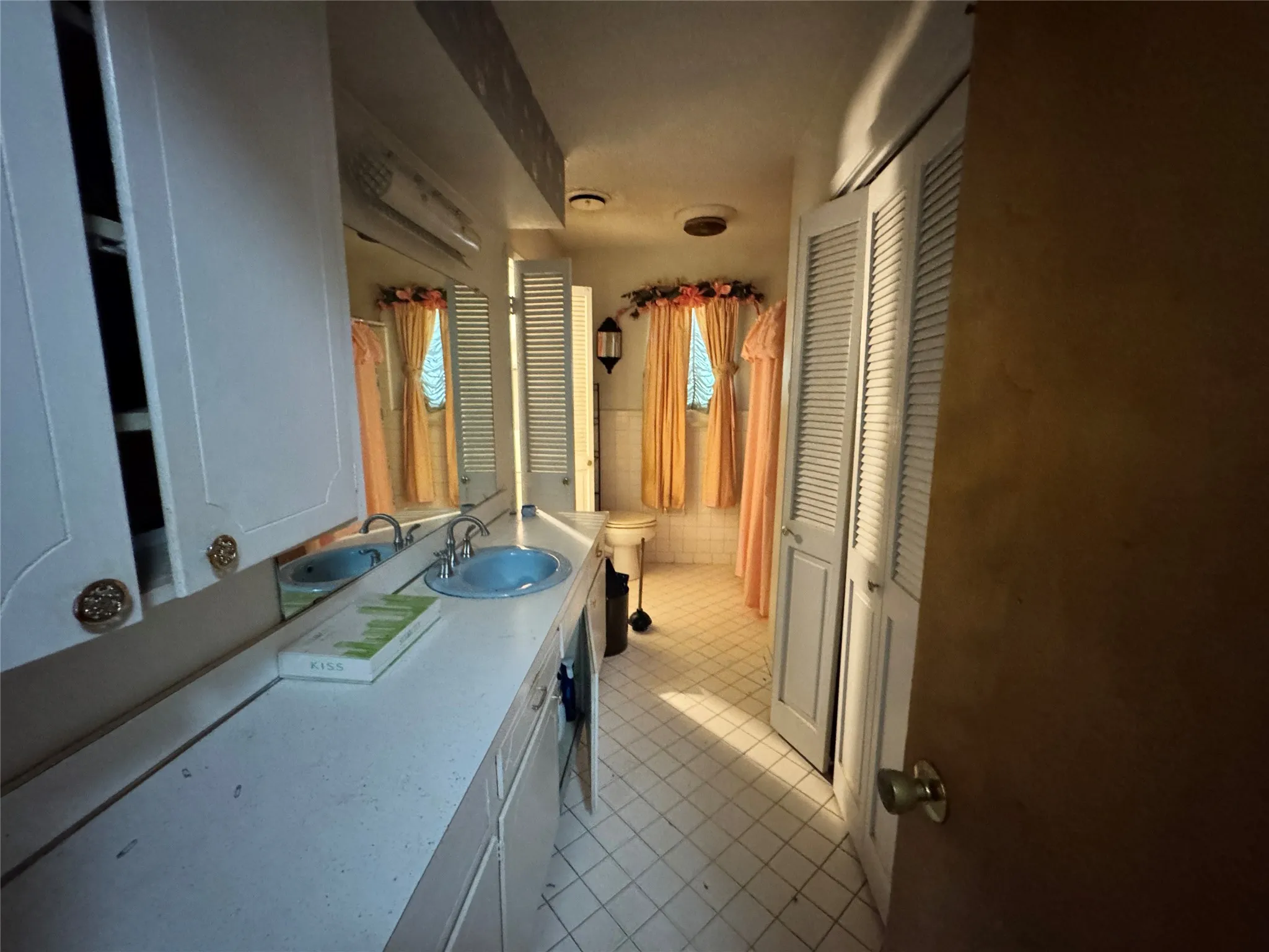 Bathroom featuring a dual vanity with light blue sinks and a white countertop - off of hallway