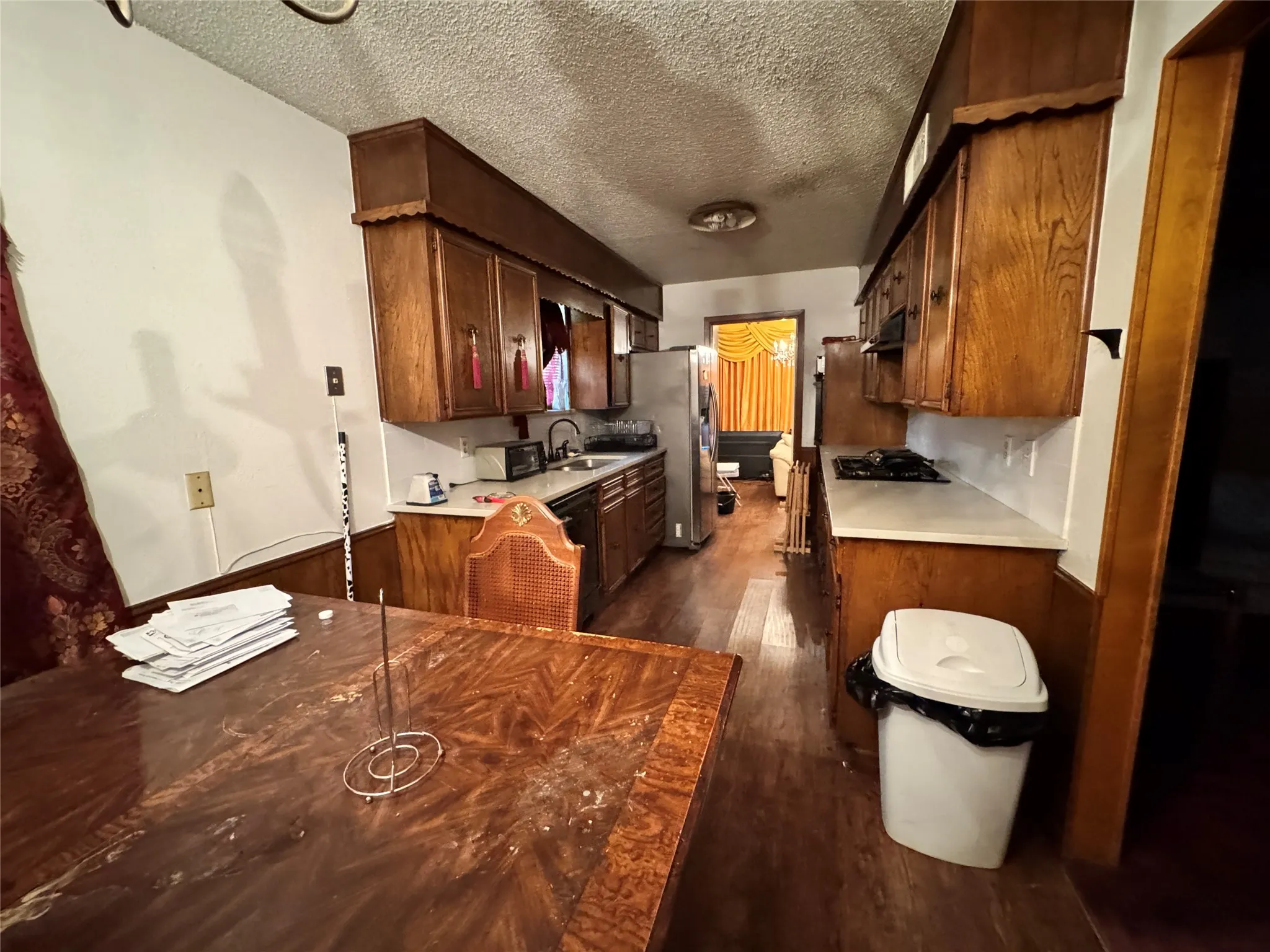 Galley Kitchen with breakfast nook area, Gas cooktop and dark wood cabinets.