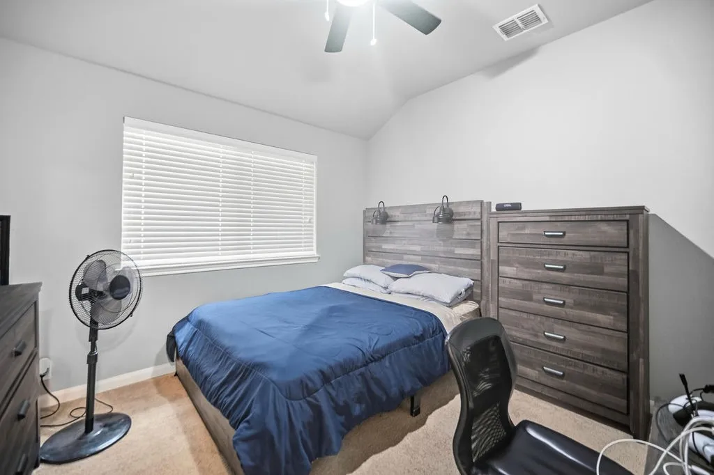 Bedroom featuring light gray walls, an angled ceiling, and carpet flooring