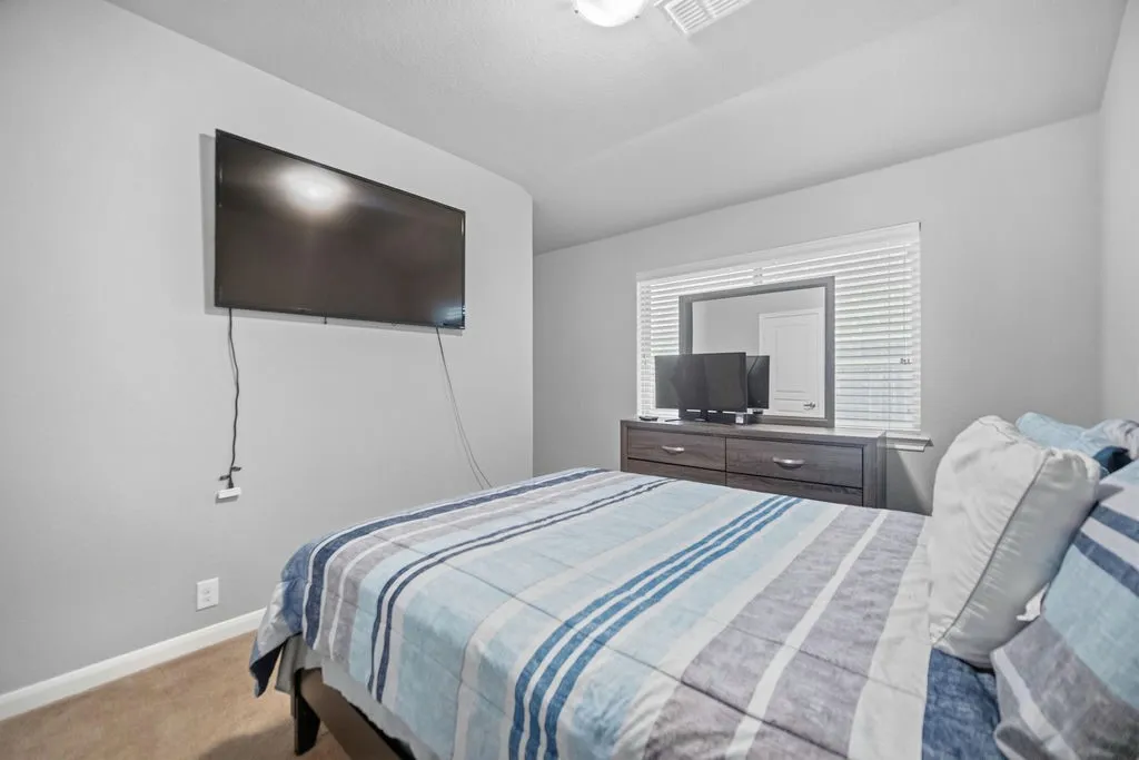 Carpeted room with light gray walls, a window with horizontal blinds, and a built-in ceiling light fixture