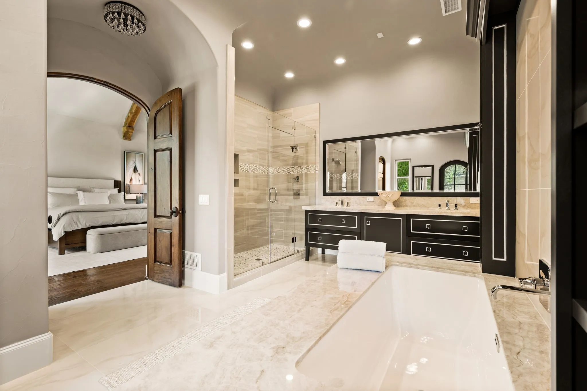The primary bath also offers two separate closets with custom shelving and enclosed glass doors.
