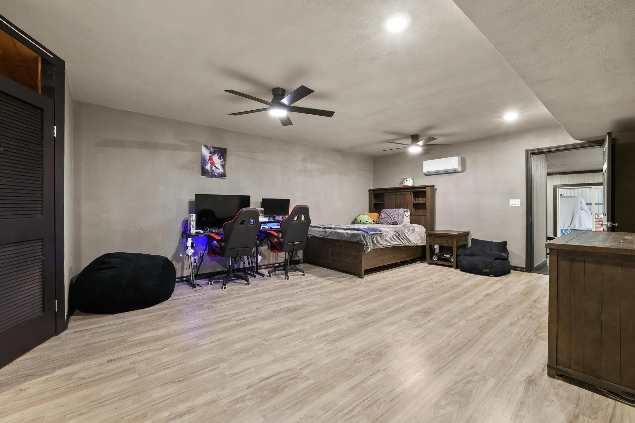 Spacious room featuring wood-finish flooring, recessed lighting, and two ceiling fans