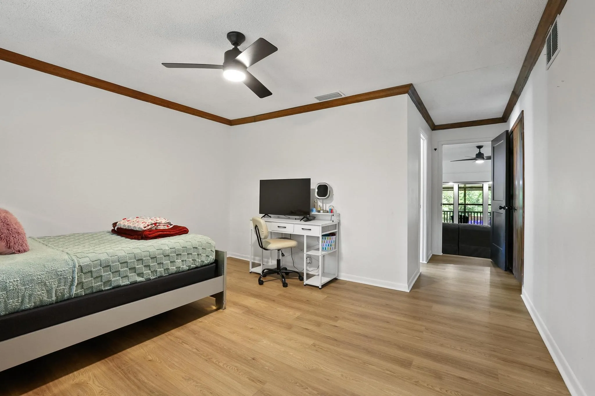 Room featuring wood-finish flooring, white walls, and dark wood trim