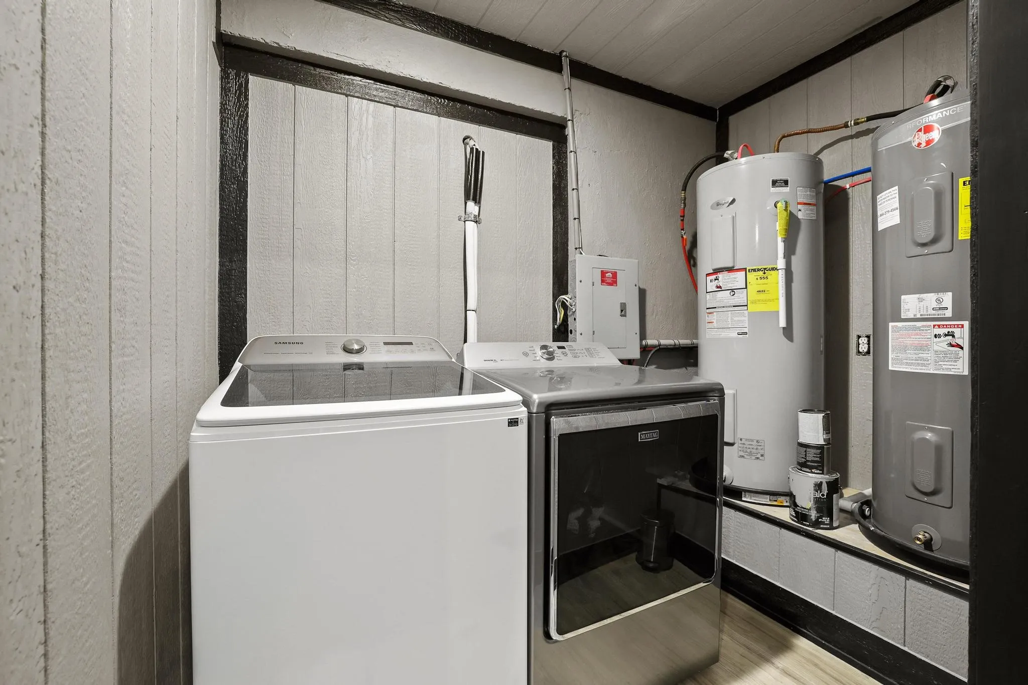 Dedicated utility area featuring a washer and dryer, two water heaters, and a visible electrical panel