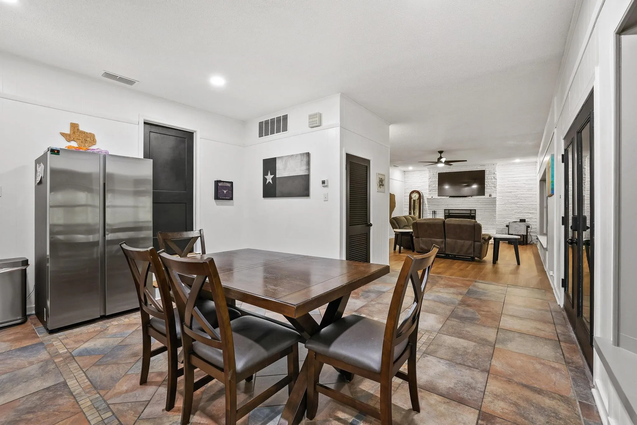 Dining area featuring multi-toned floor tiles and a dark wood-finish dining table