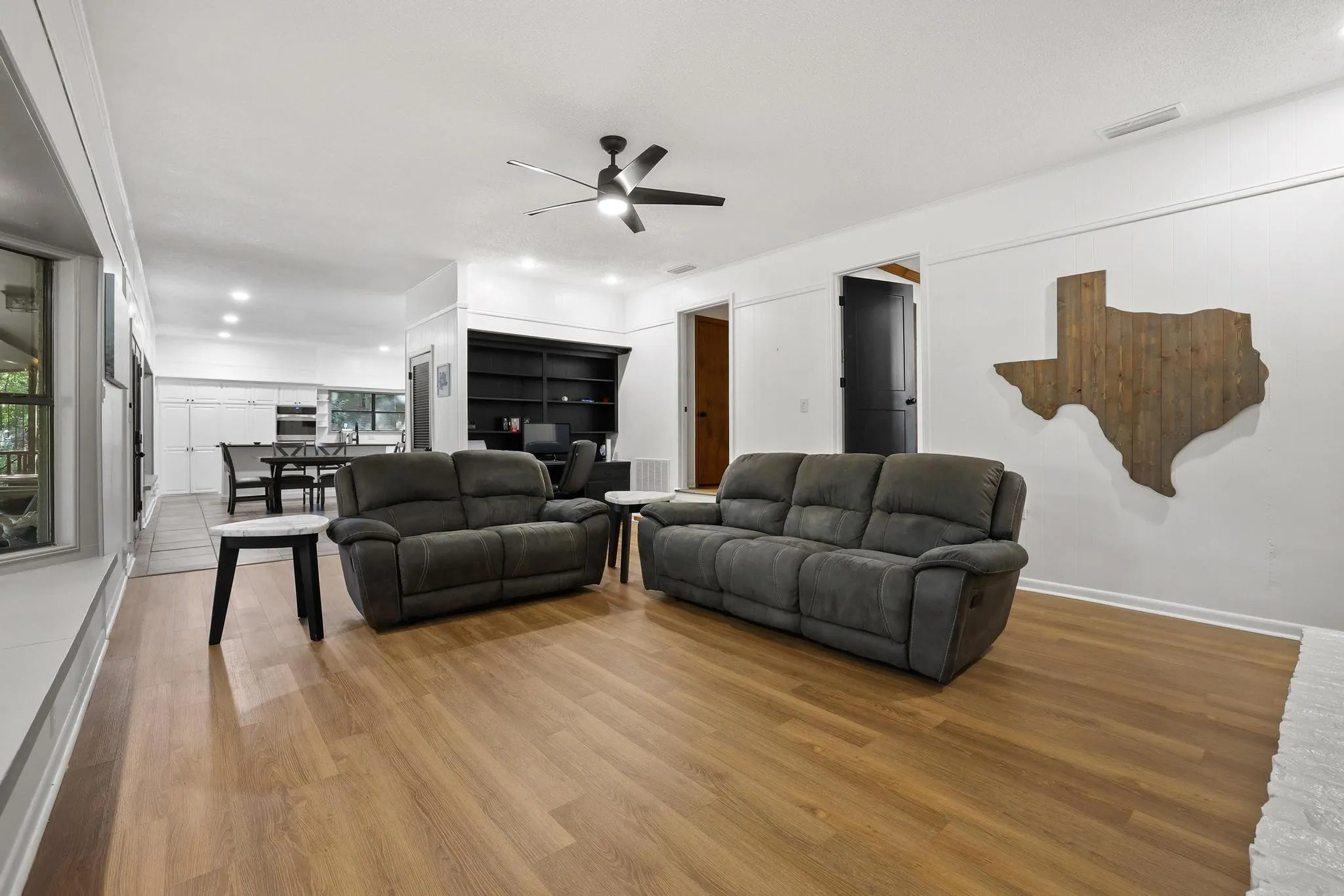 Bright living area featuring wood-finish flooring, recessed lighting, and a contemporary ceiling fan