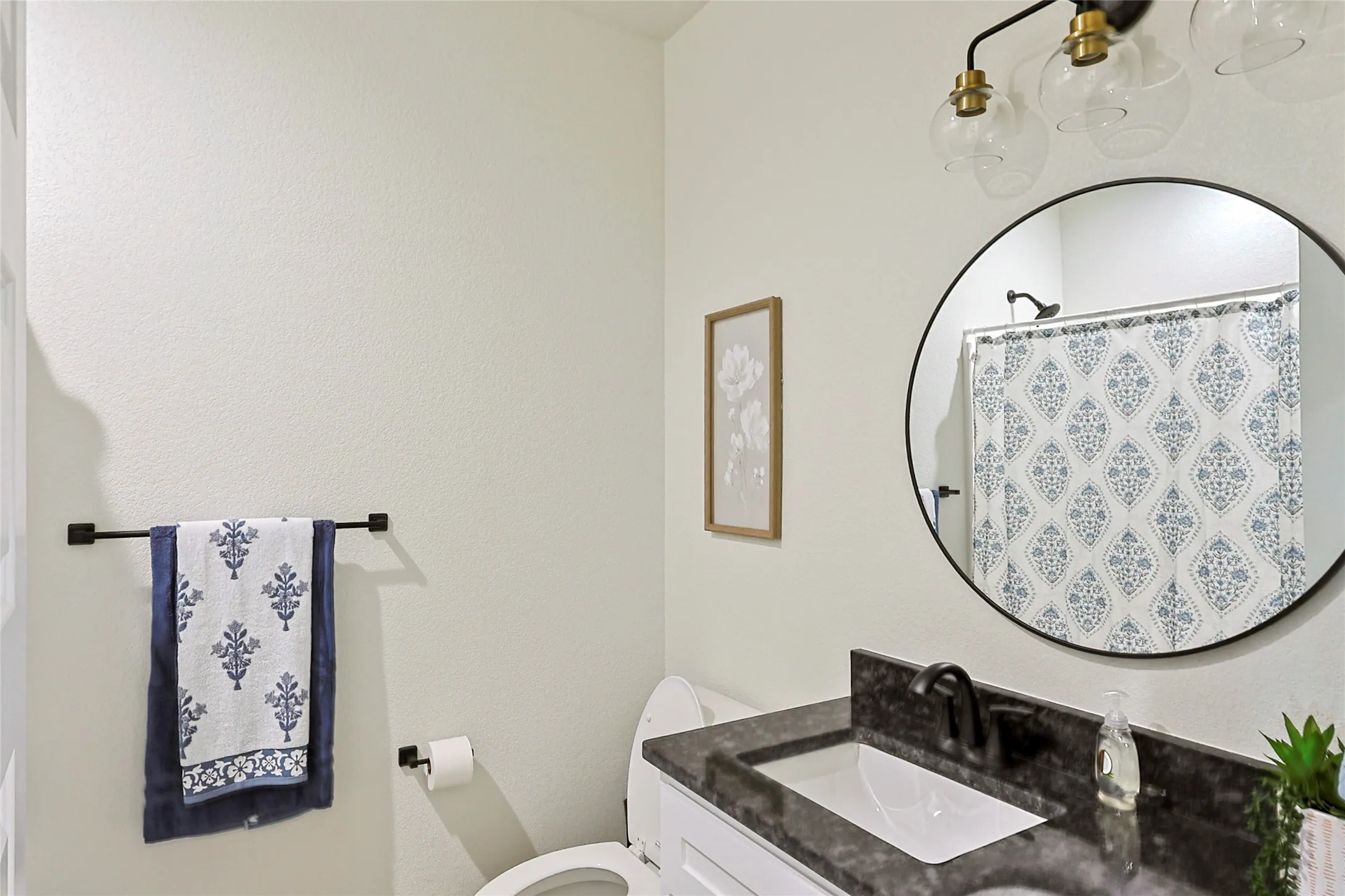 Bathroom vanity featuring a dark stone countertop, undermount sink, and matte black faucet
