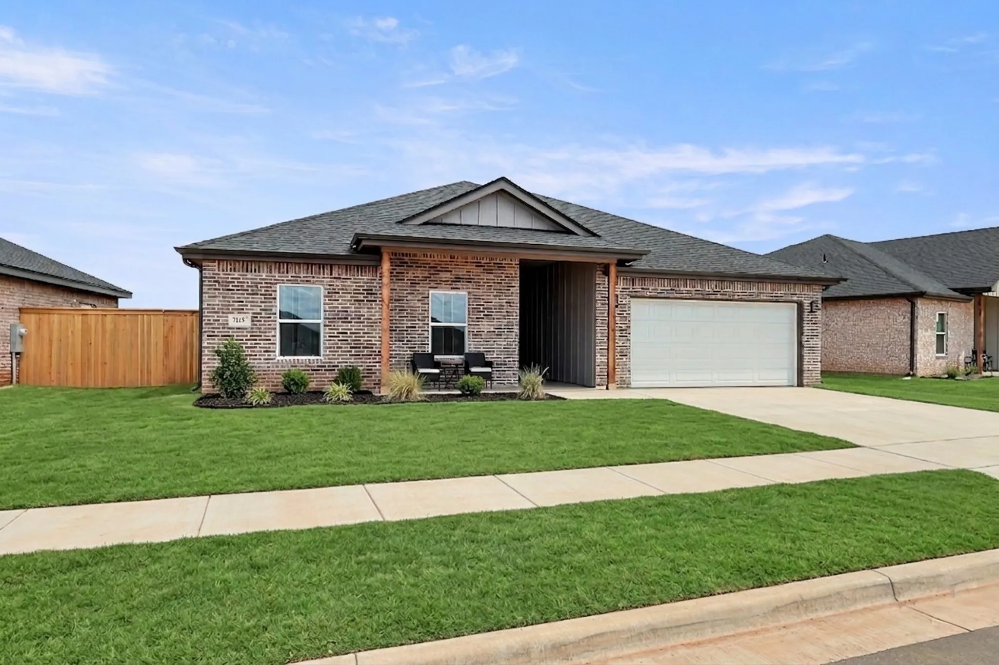 Brick exterior with a dark shingle roof and a two-car garage