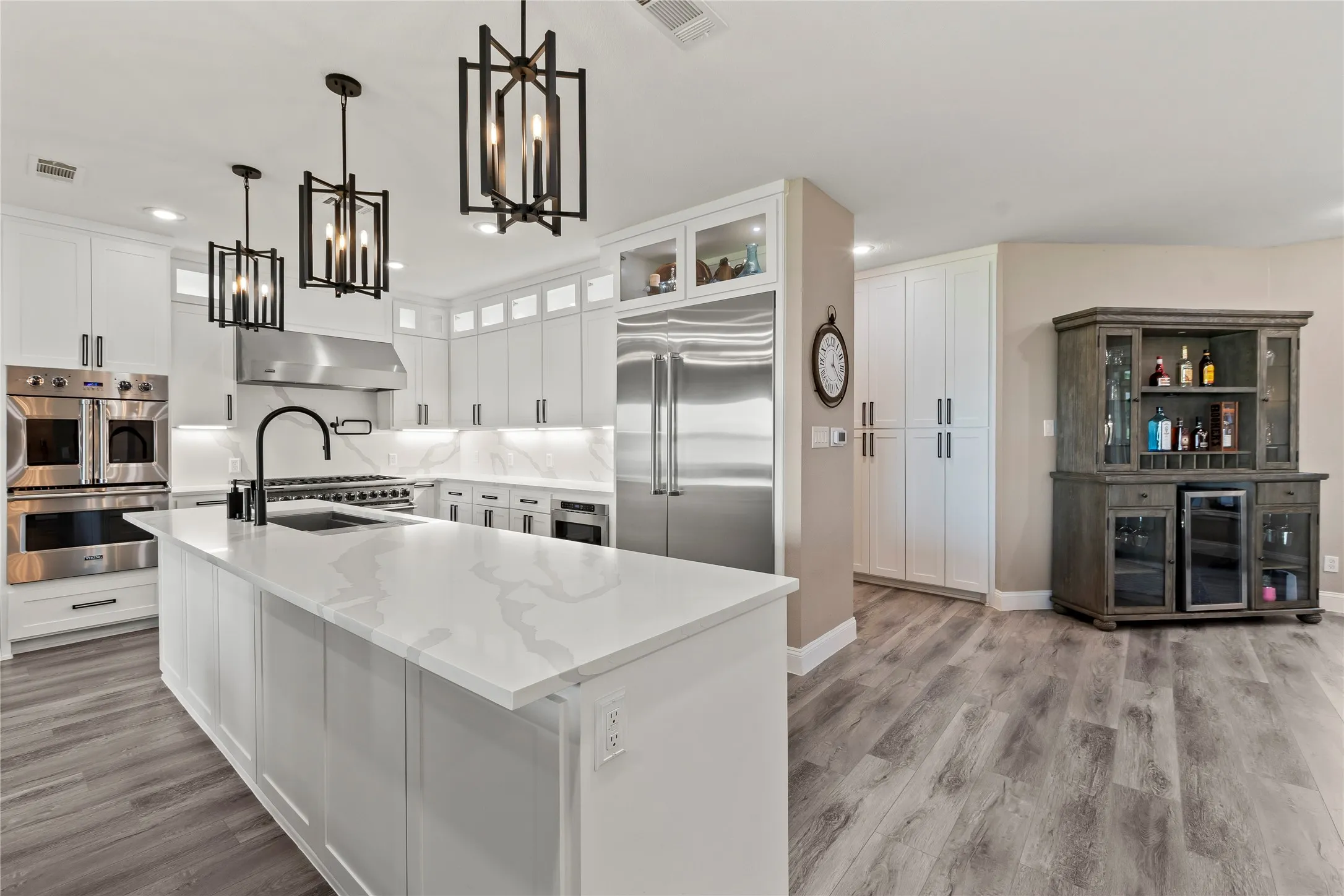 8-burner Viking gas range with double ovens.
Two additional wall ovens for entertaining convenience.
Built-in refrigerator creates a seamless kitchen design.
