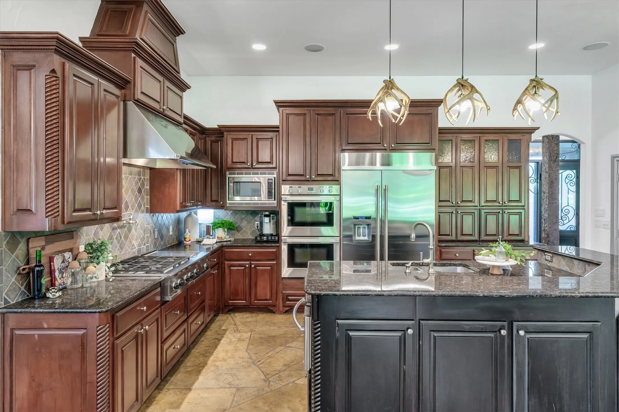 Well appointed kitchen has double ovens, a pot filler, gas cooktop, built in refrigerator, dual dishwashers and a warming drawer.