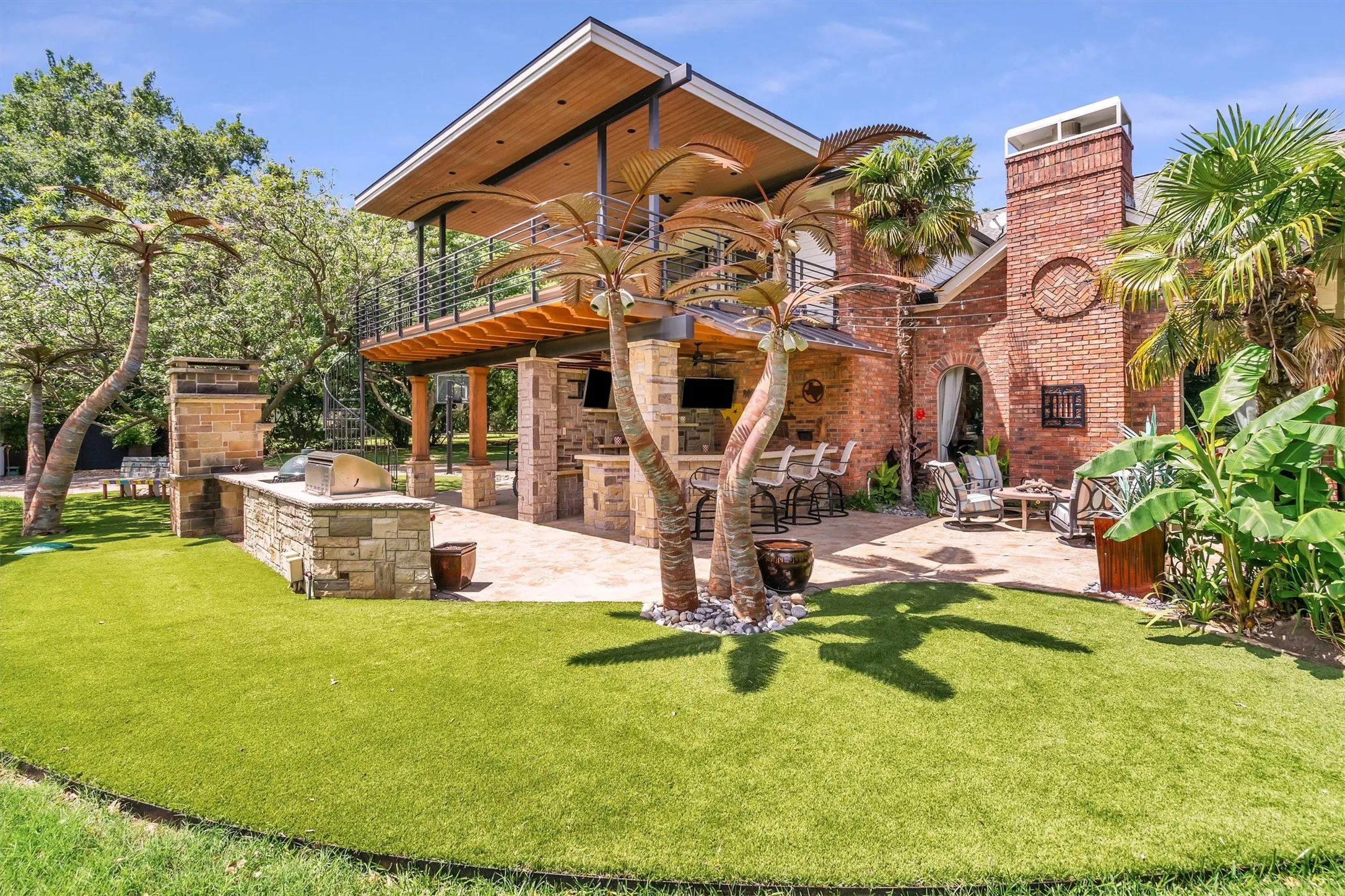 The back yard includes a large bar, built in grill, Green Egg and pizza oven, putting green, balcony, and extended covered patio. Huge grass space for play or events.