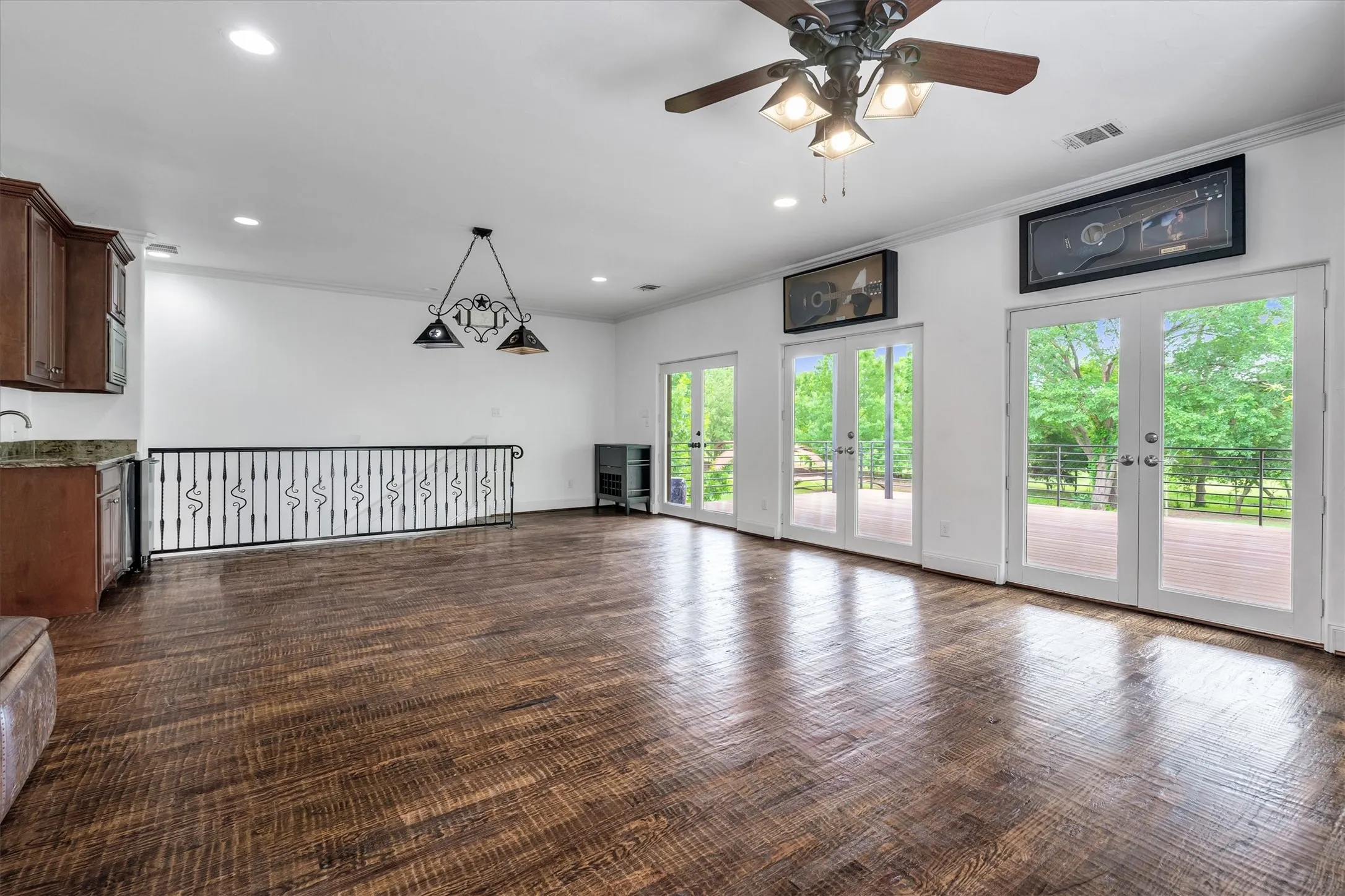 Upstairs Game Room with hardwood flooring and a bar leading to an awesome covered patio, overlooking the expansive back yard.