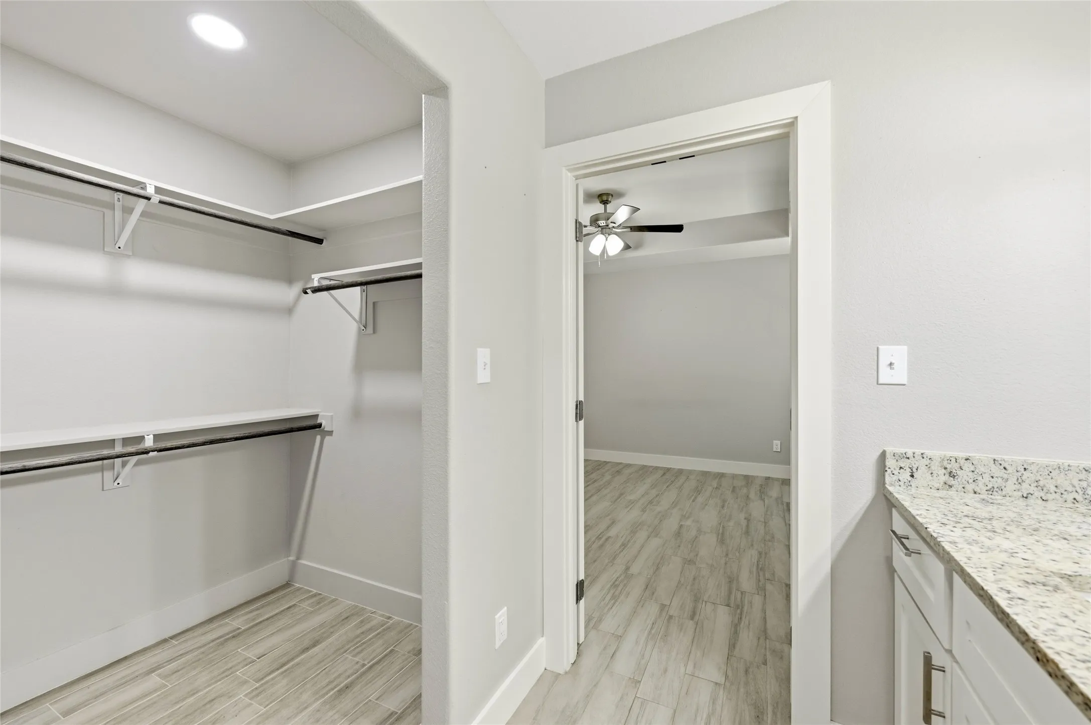 Walk-in closet with built-in shelving and hanging rods, recessed lighting, and ceramic flooring