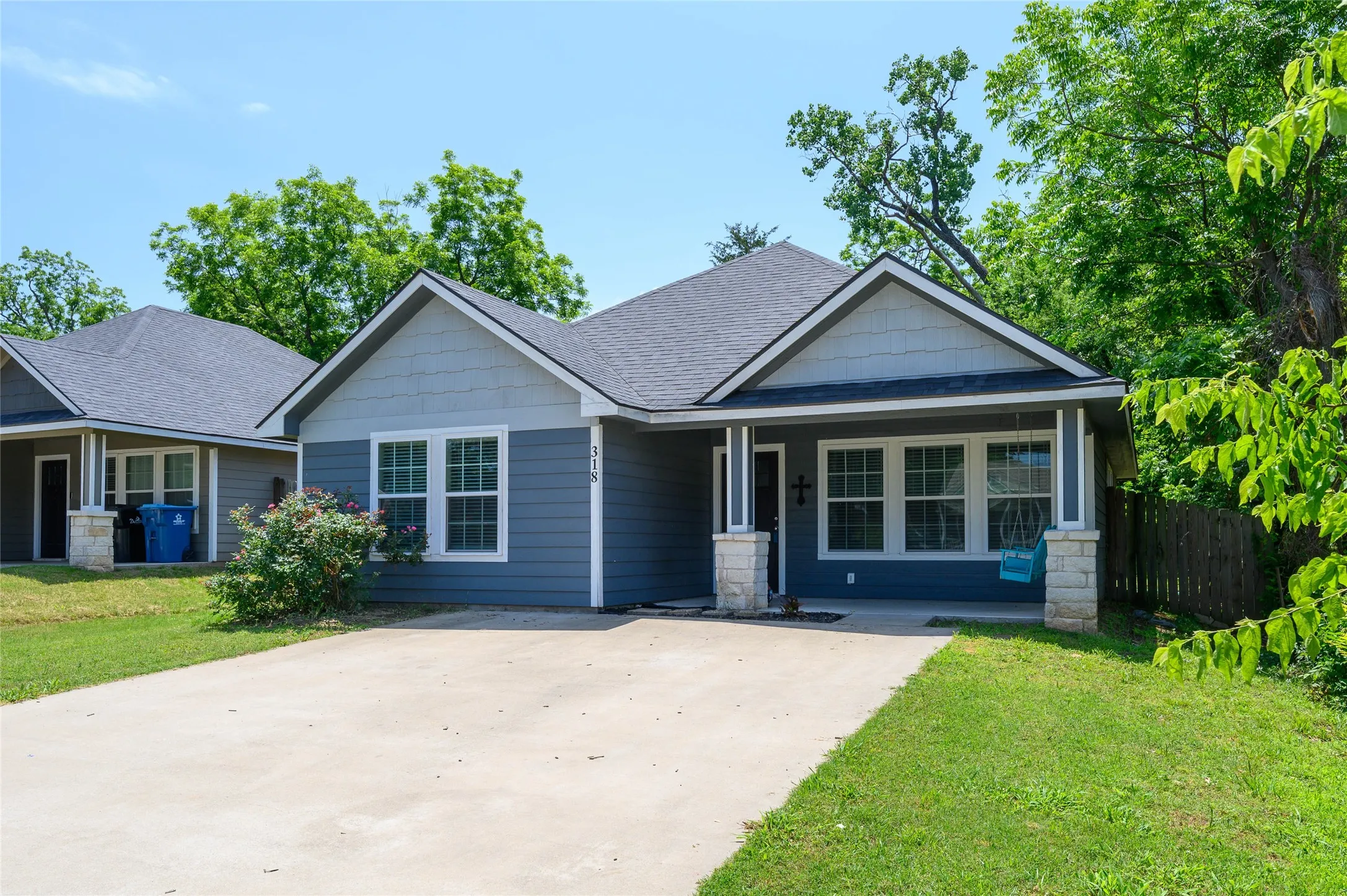 Contemporary-style home featuring a gray shingle roof, blue siding, and white trim