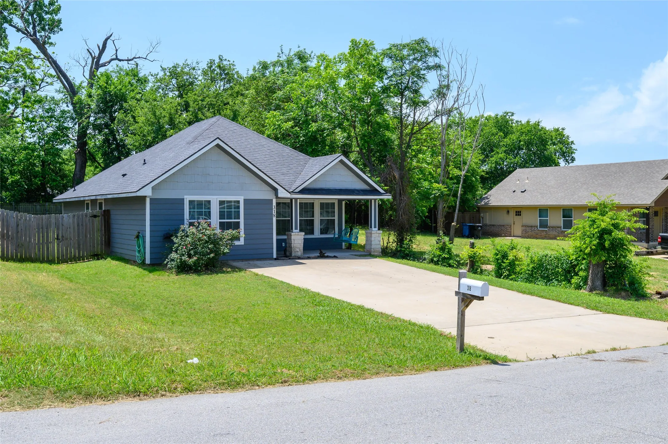 Single-story residence featuring blue siding with light gray gable accents and a dark gray shingle roof