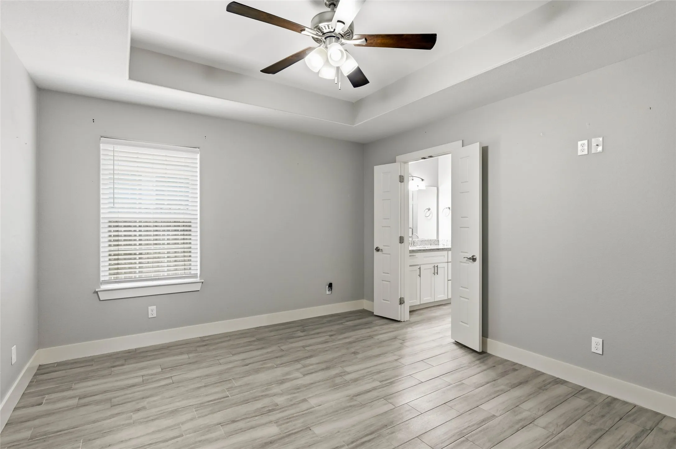 Primary Bedroom, ceramic tile flooring, wide baseboards, ceiling fan, outlets on every wall.