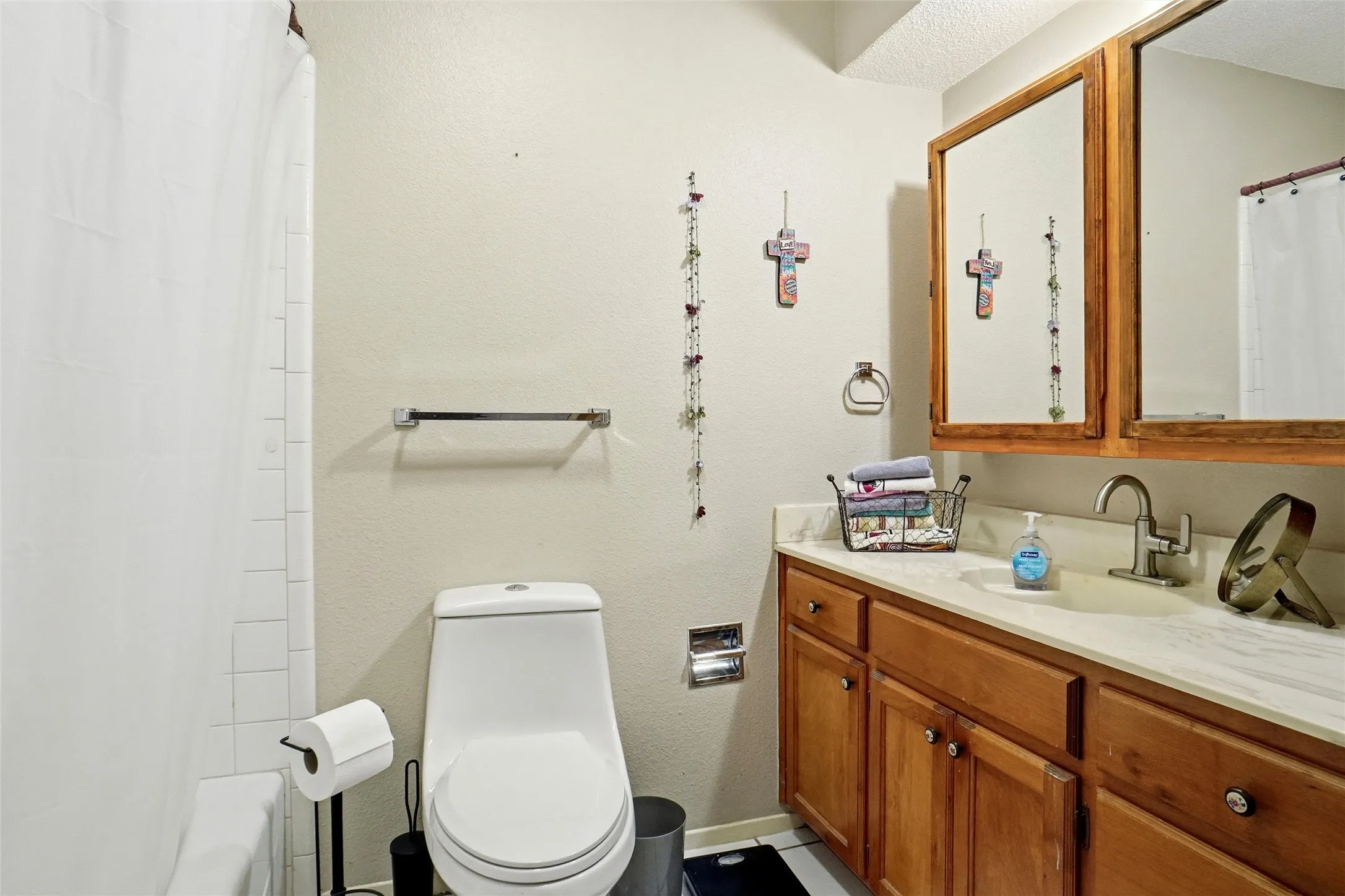 Primary Bathroom featuring a wood-finish vanity with a light-colored countertop and integrated sink
