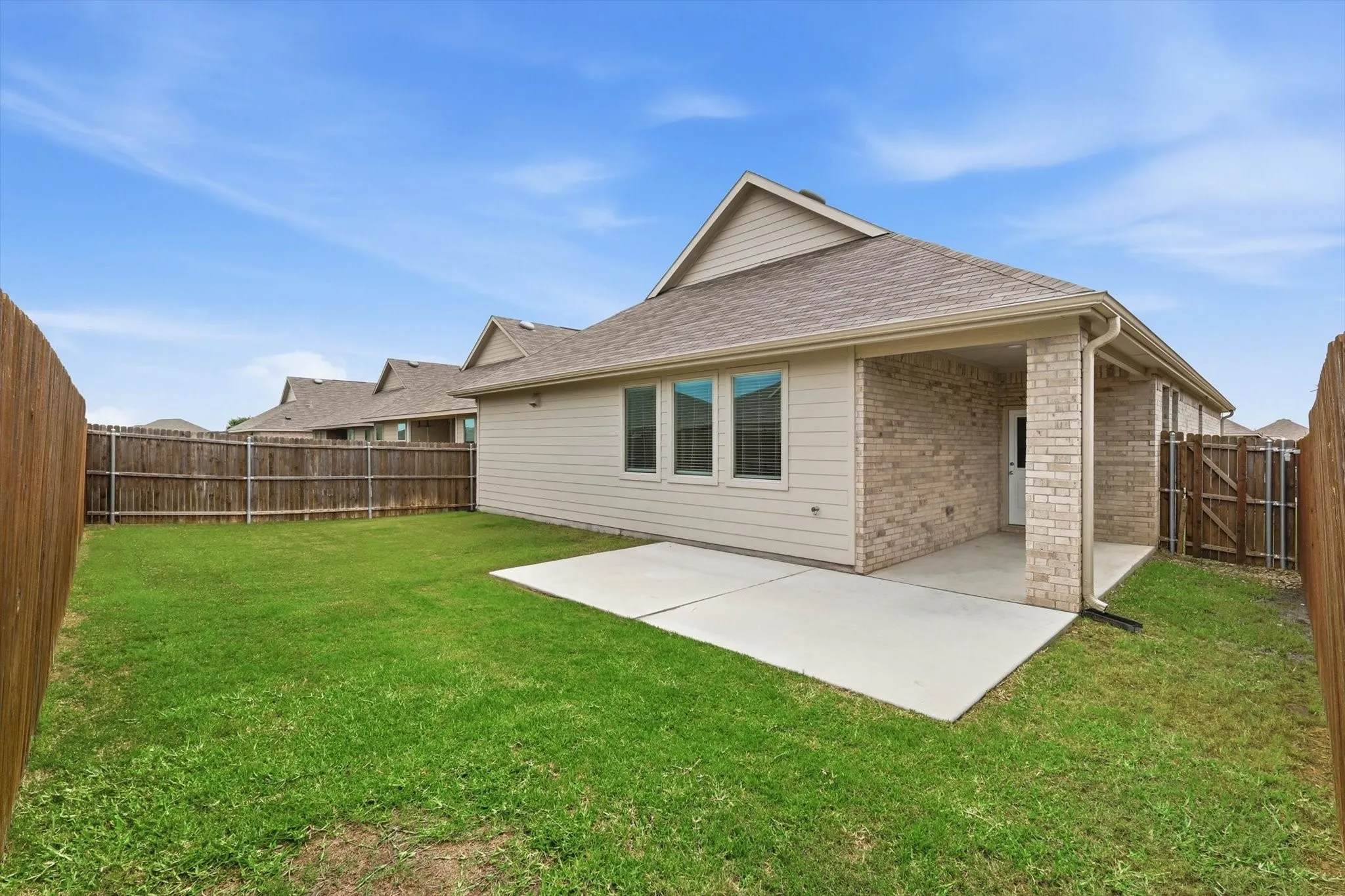 Backyard features extra patio slab. This home also has rain gutters.