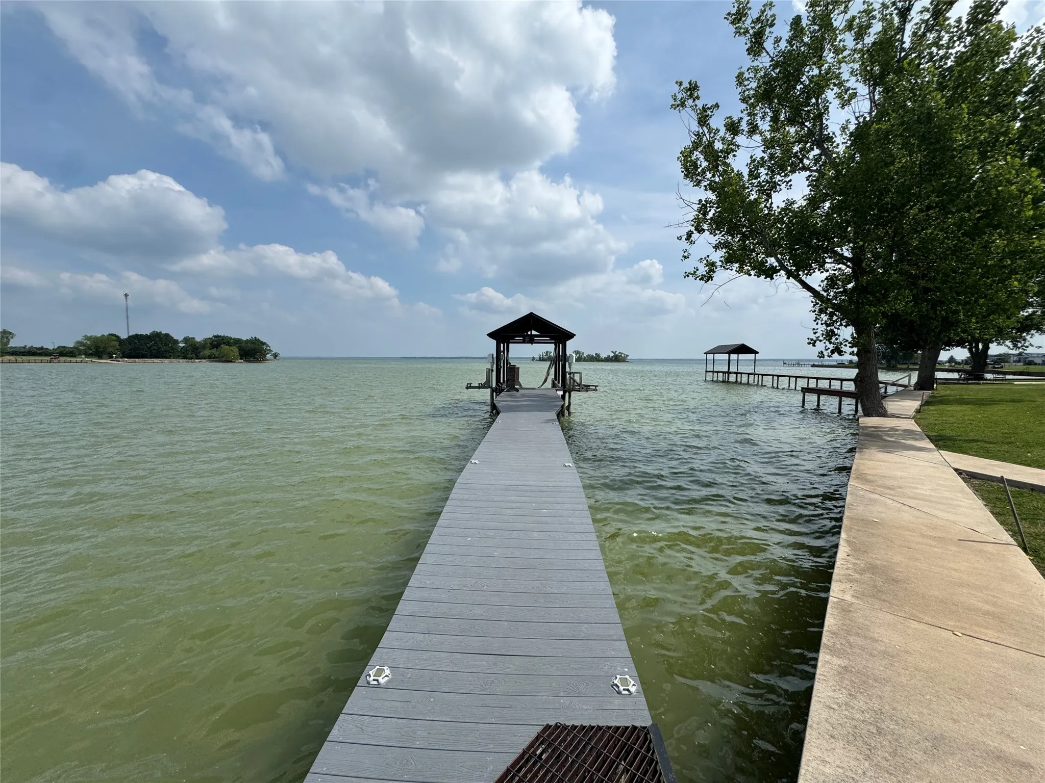 Waterfront pier featuring a covered boat lift, extending over the water