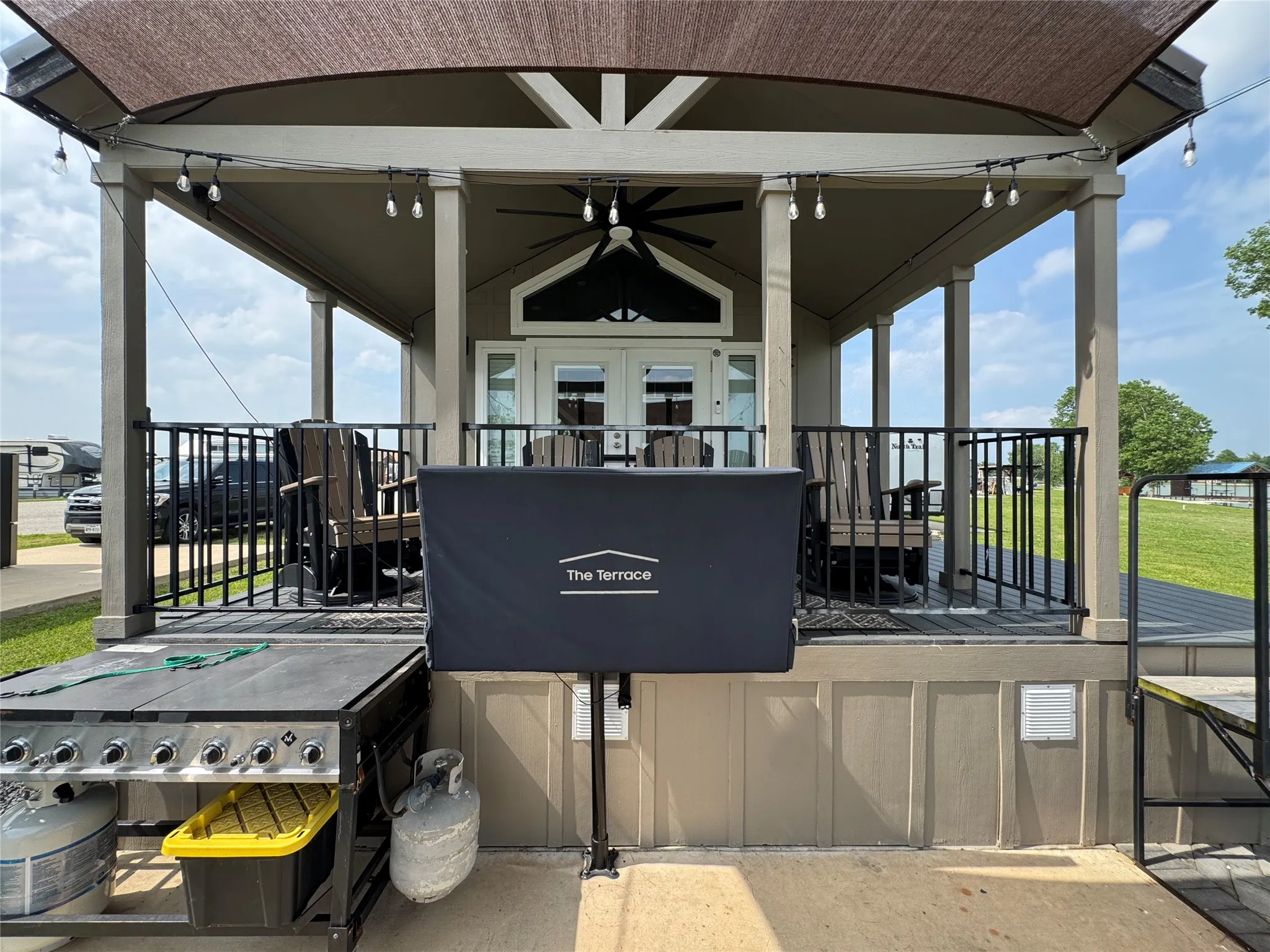 Covered porch with dark wood-finish decking and black metal railings
