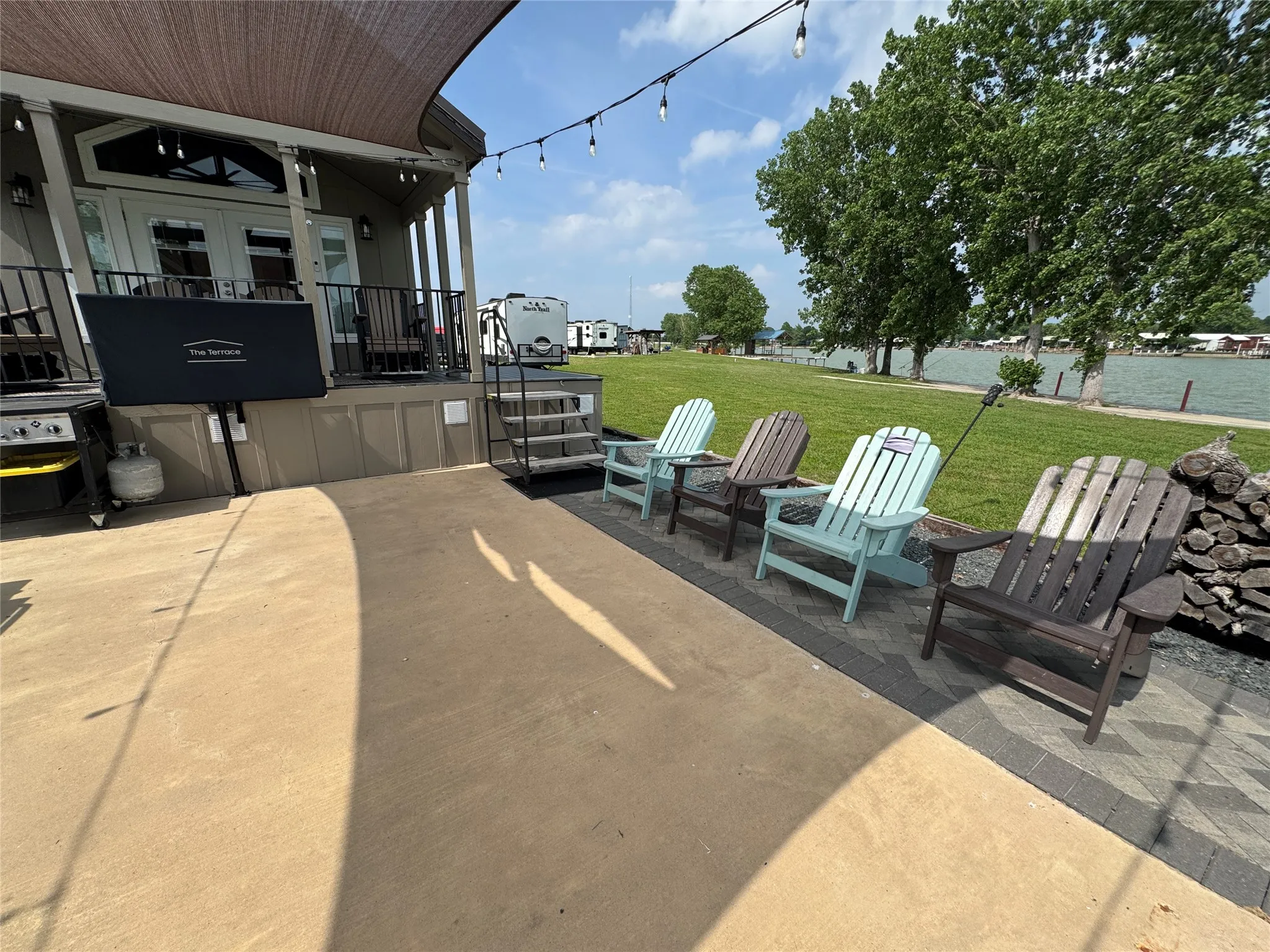 Expansive concrete patio with string lighting and a shade sail