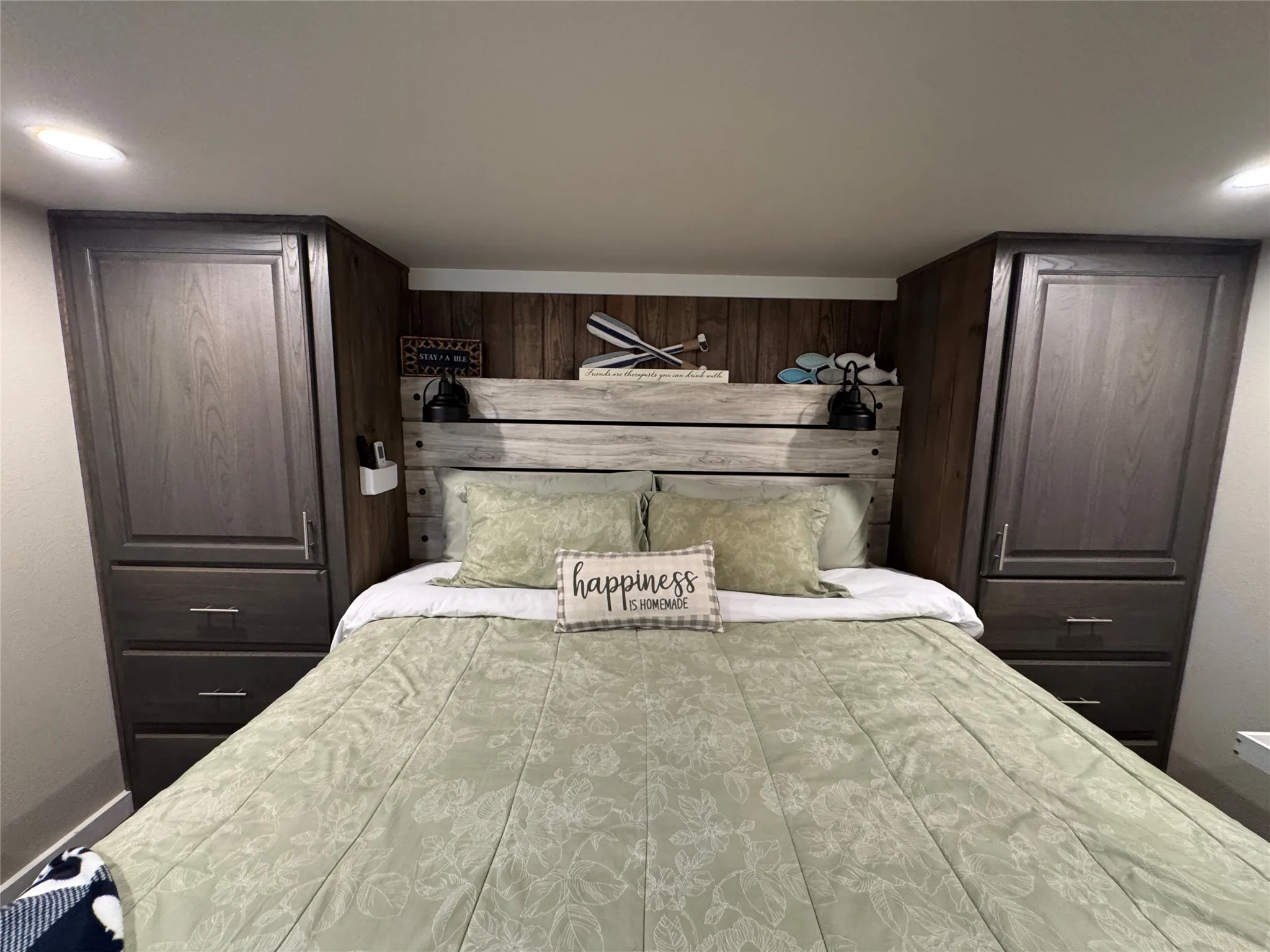 Built-in storage cabinetry flanking a wooden headboard, accentuating a feature wall with vertical wood paneling