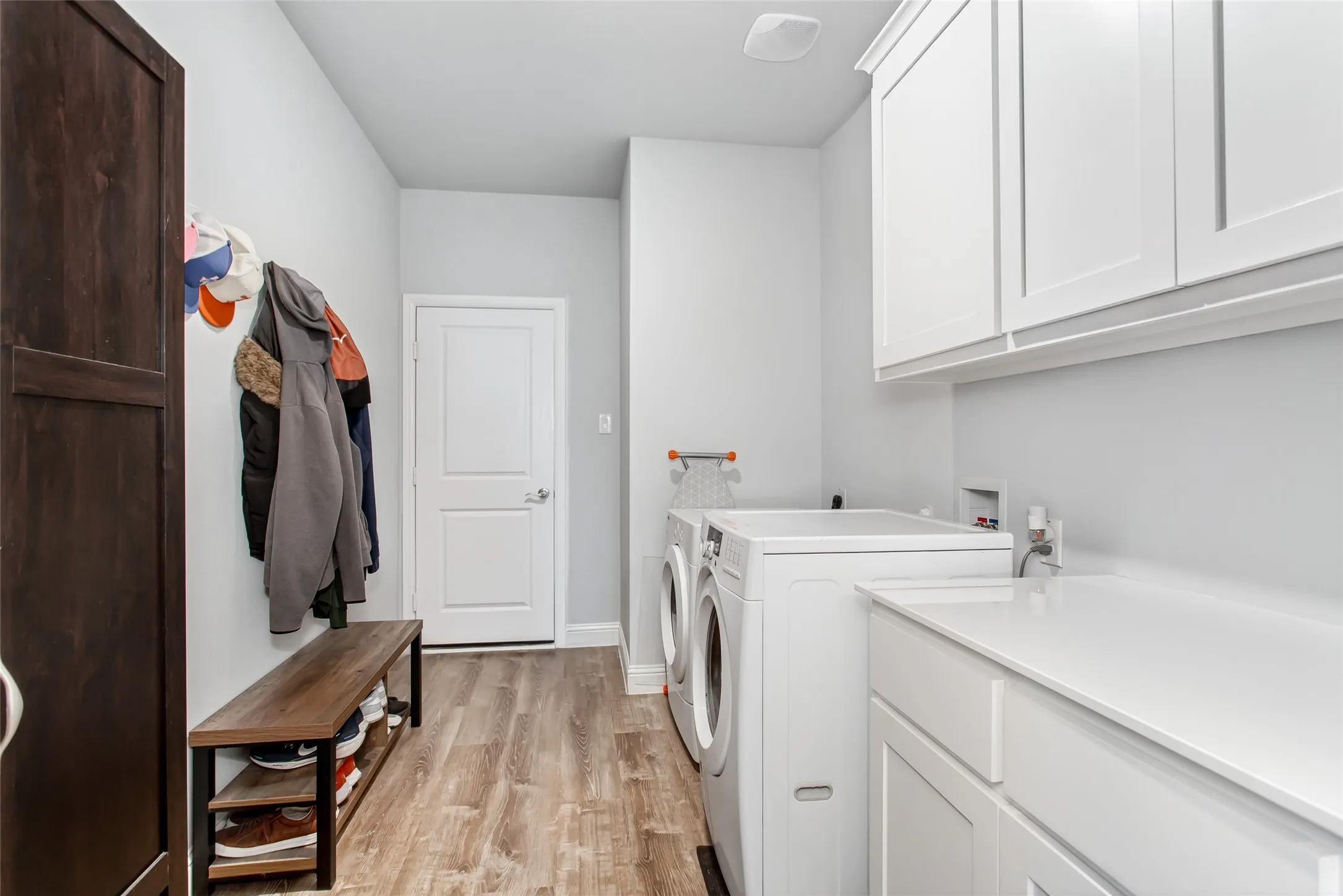 Spacious utility room with built-in upper and lower cabinetry, folding counter space, and room for additional storage or organization.