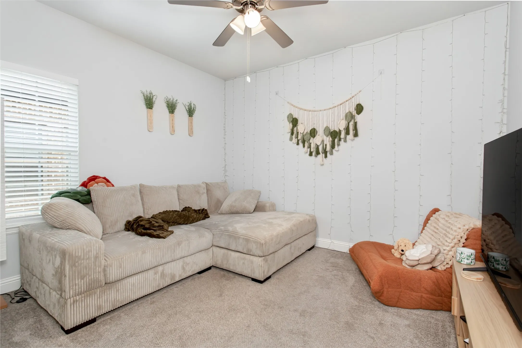 Versatile secondary bedroom currently staged as a cozy second living area, perfect for a media room, playroom, or flex space.