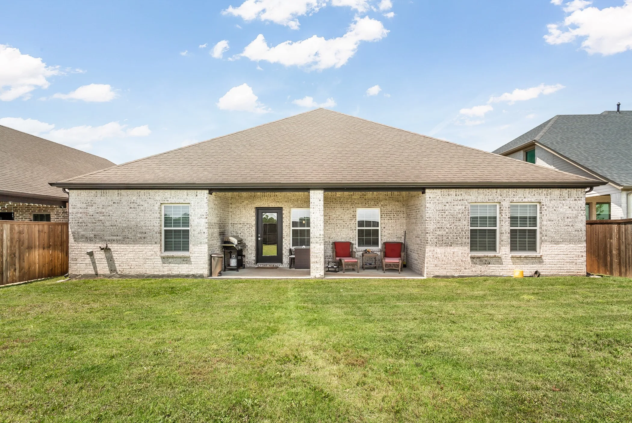 Generous backyard offers endless possibilities with ample room to entertain, garden, play, or simply enjoy the privacy and open space under the covered patio.