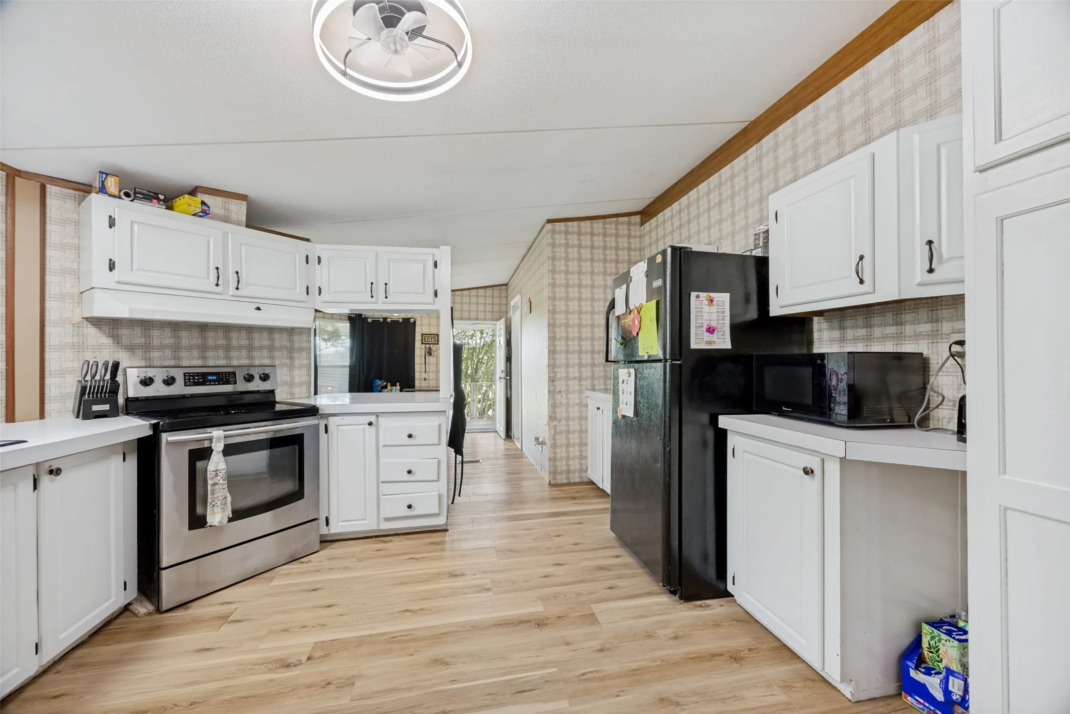 Kitchen featuring smooth flooring throughout the kitchen, dining areas and living room.  There are some areas that the subfloor needs attention.
