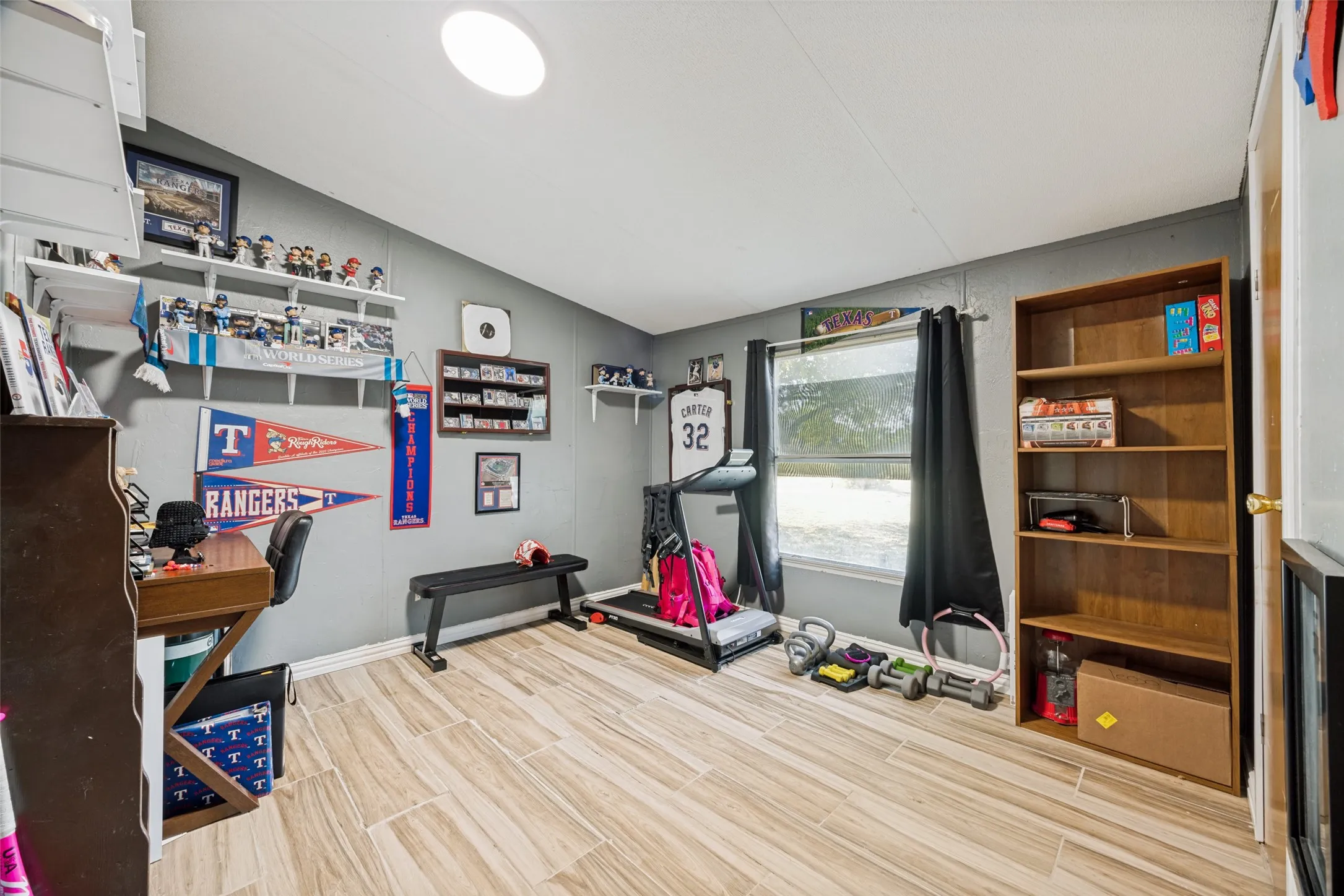 Bedroom #3 measuring 10x10 is currently set up as the "man cave" and exercise room.  Features shelving and smooth flooring.