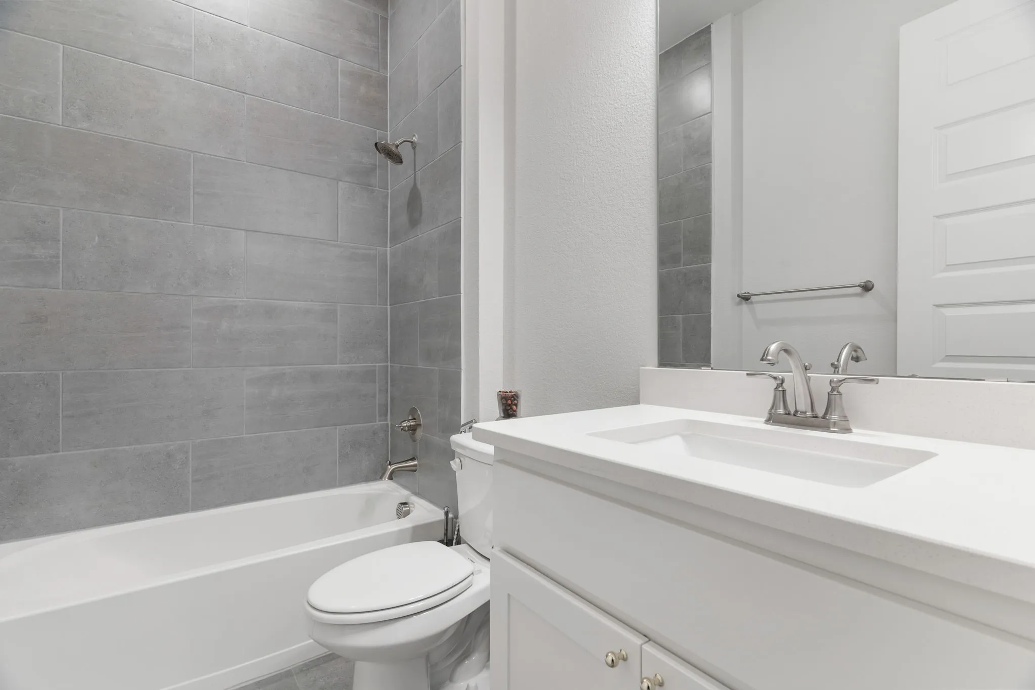 Full bathroom featuring toilet, vanity, and tiled shower / bath