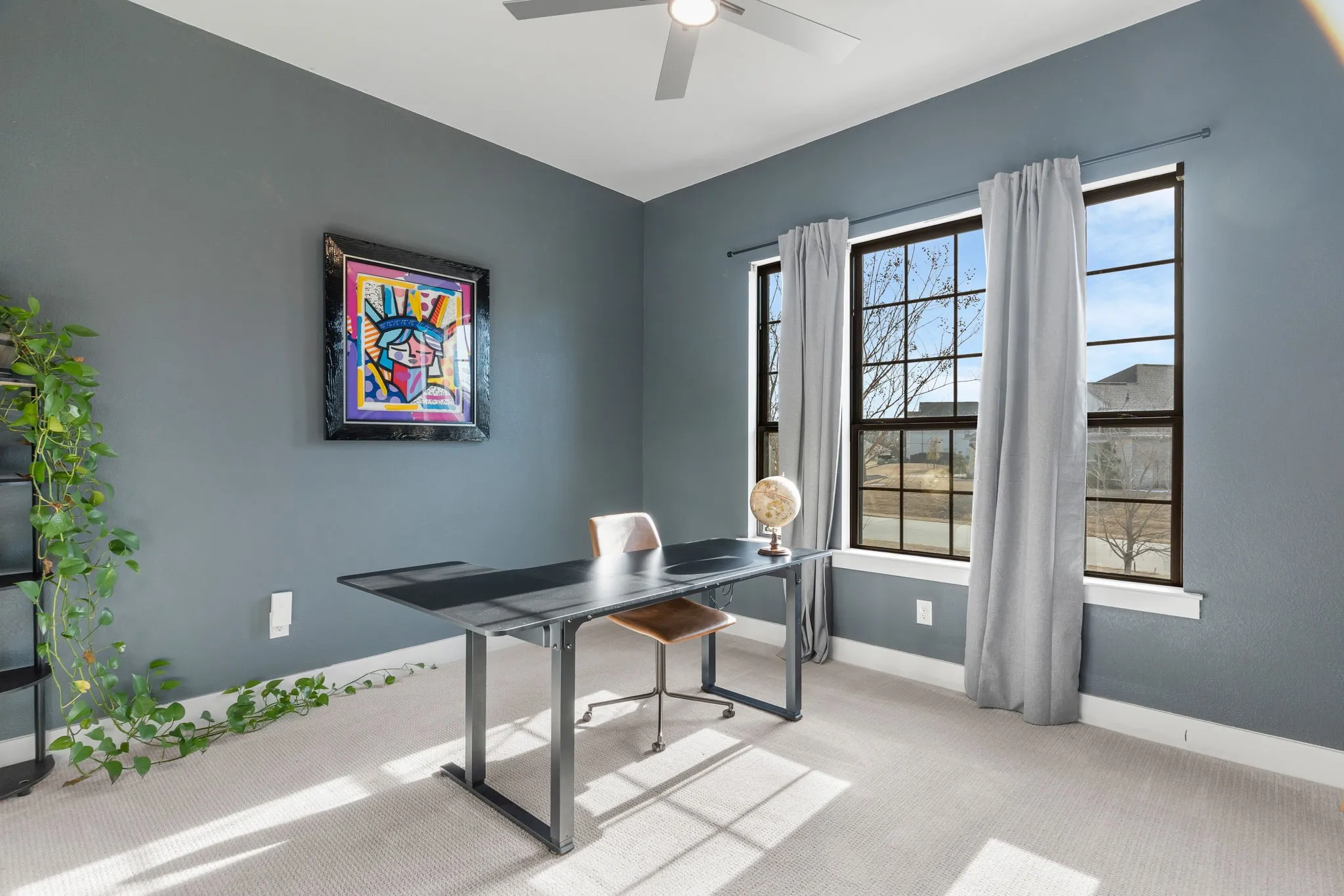 Office space featuring ceiling fan, light carpet, and a healthy amount of sunlight