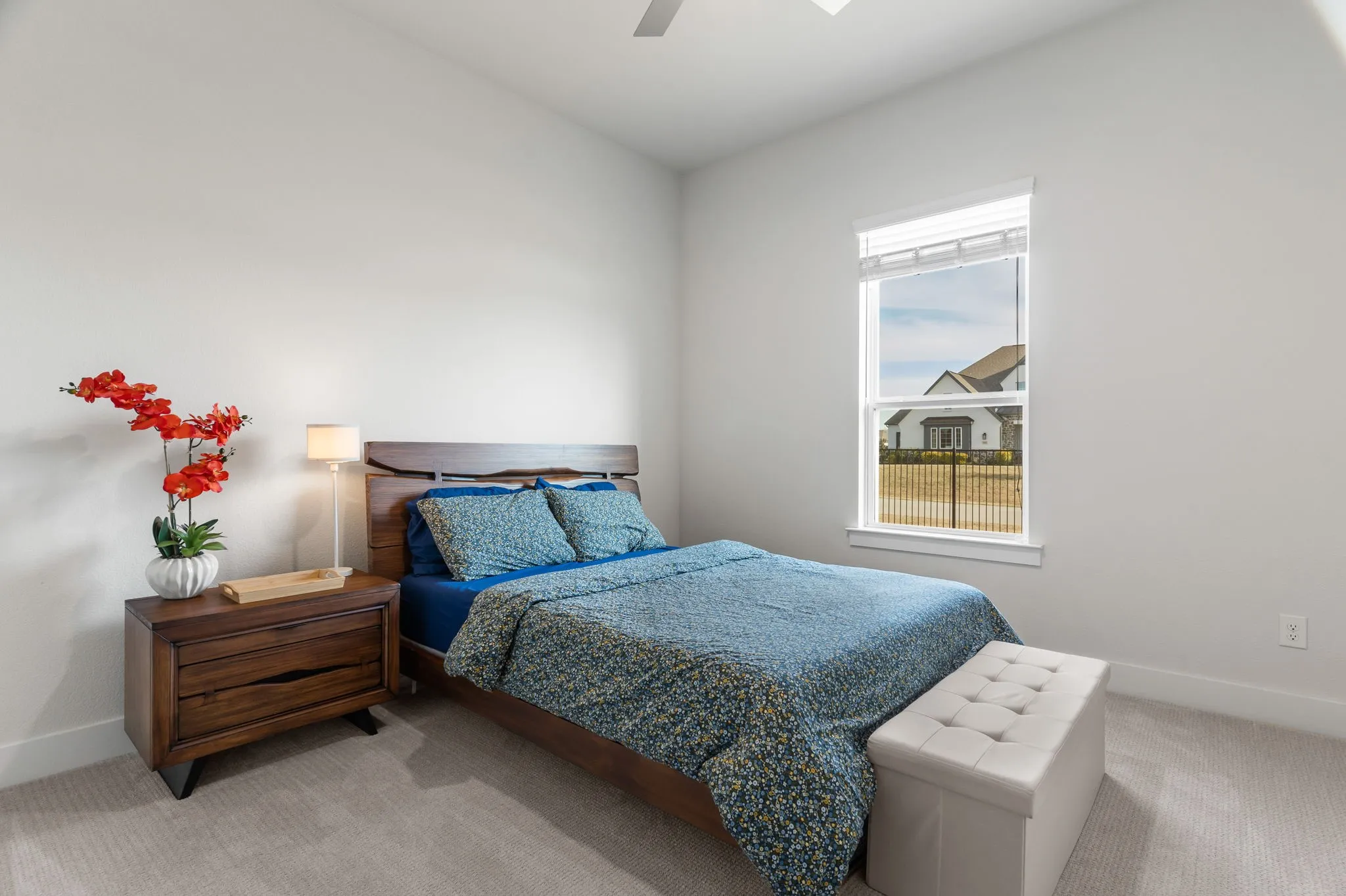 Bedroom with ceiling fan and light colored carpet