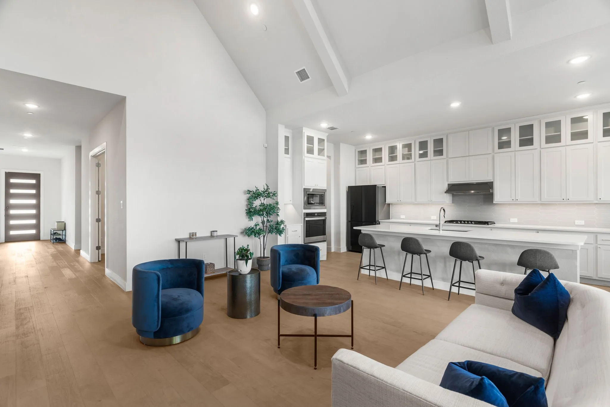Living room featuring open floor plan light hardwood flooring, high vaulted ceiling