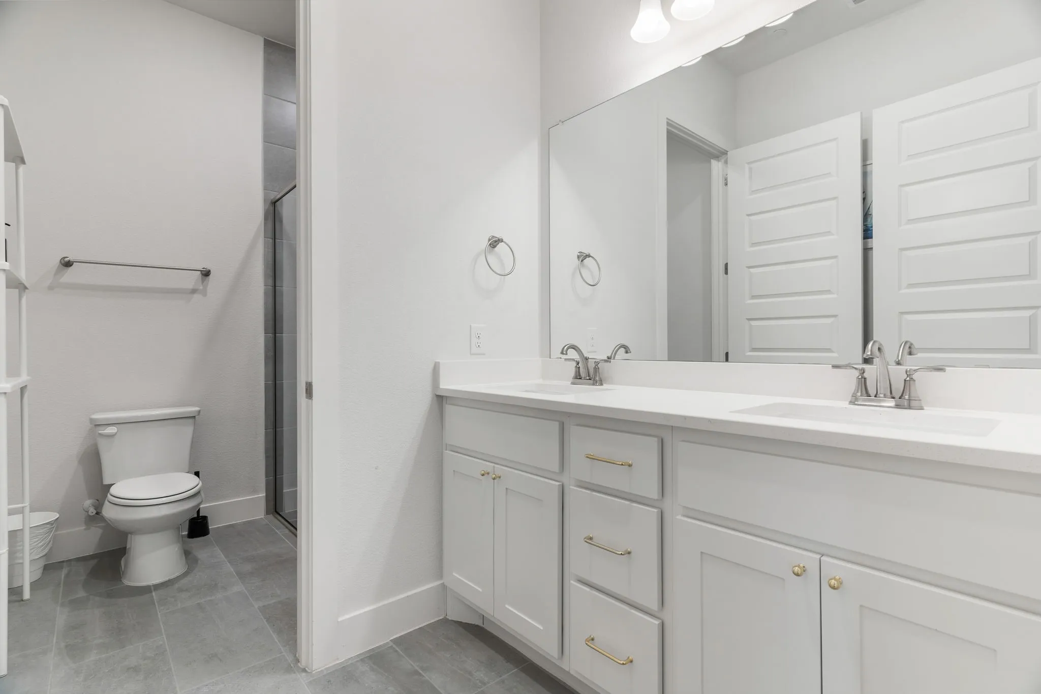 Bathroom with an enclosed shower, vanity, and toilet