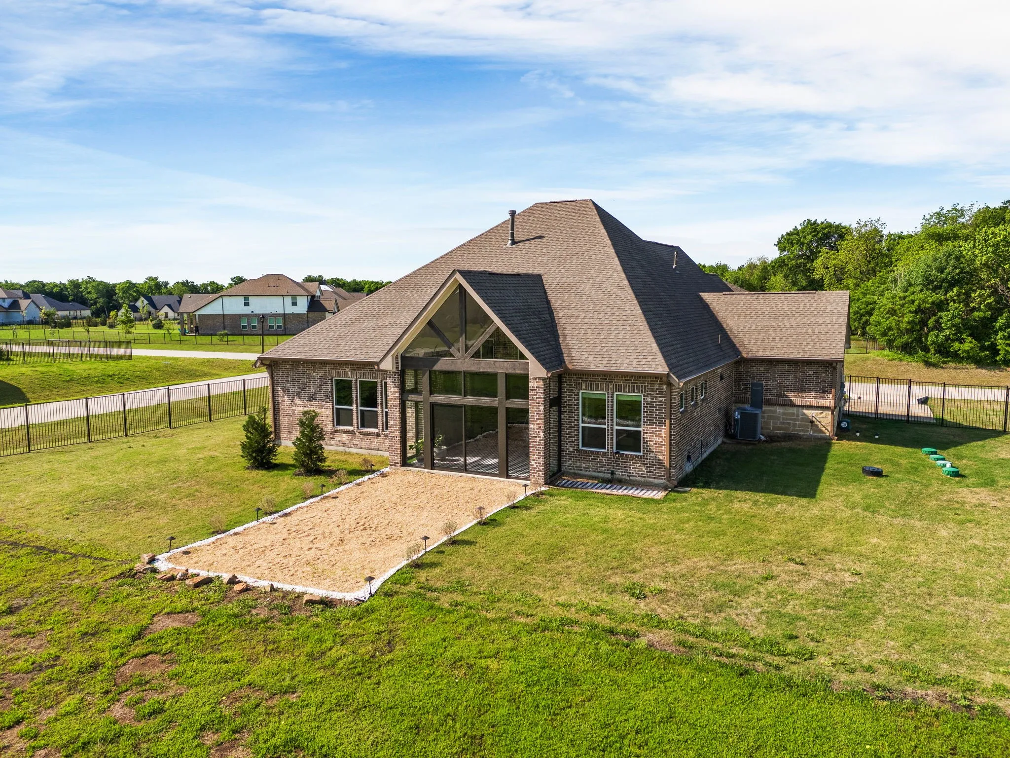 Back of house with fence, a yard, a shingled roof, and brick siding