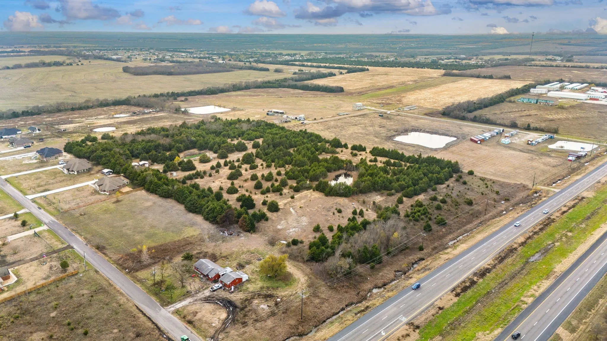 Expansive rural acreage featuring a mix of cleared land and wooded areas