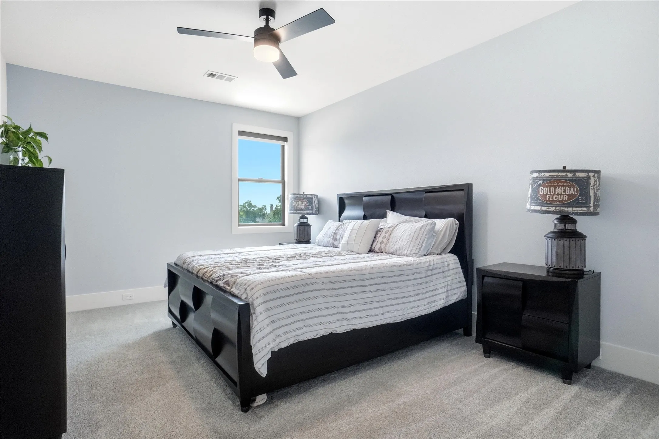 Carpeted interior with light-toned walls, a window offering exterior views, and a ceiling fan with integrated lighting