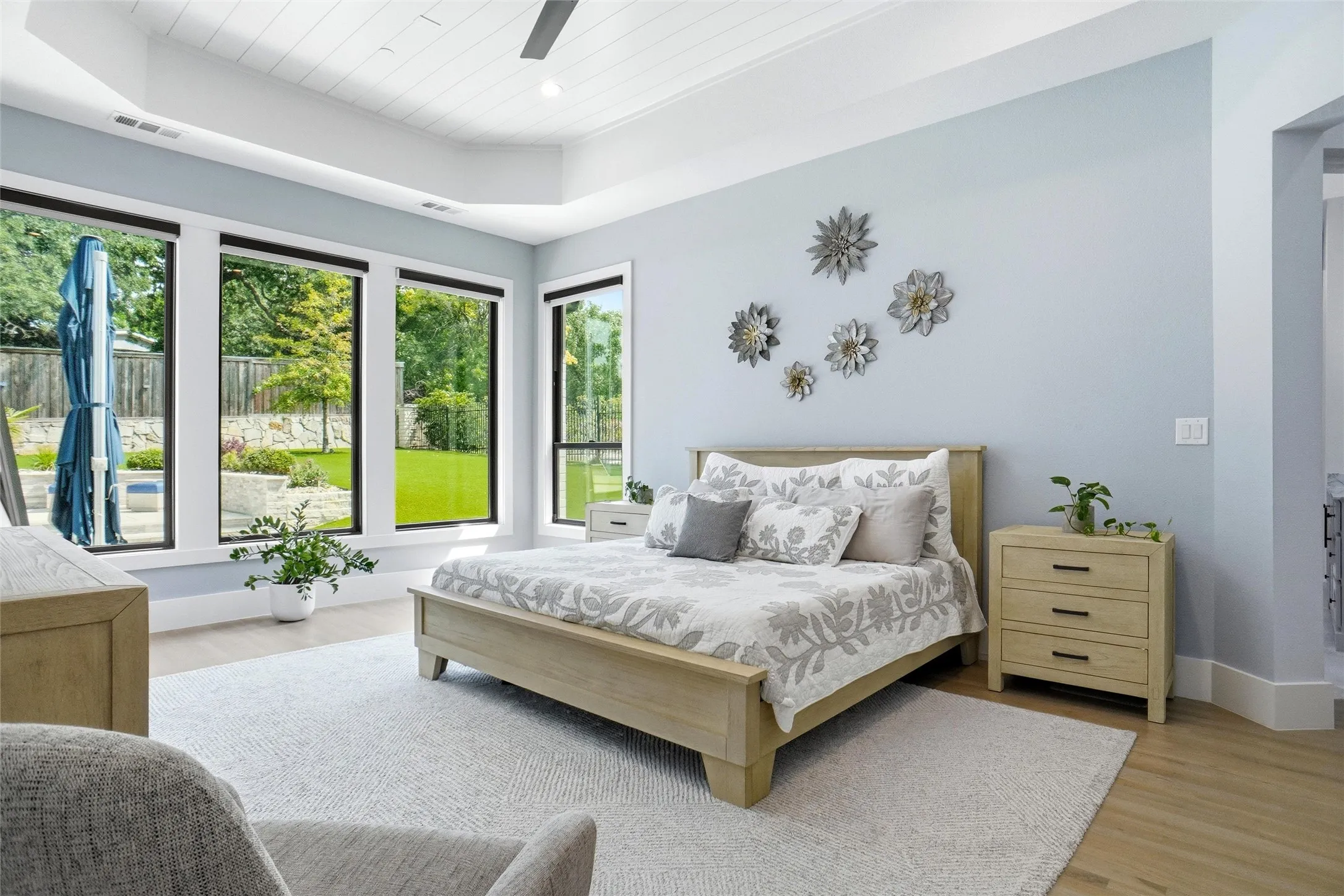 Spacious room featuring multiple large windows, a vaulted ceiling with a ceiling fan, and light wood-finish flooring