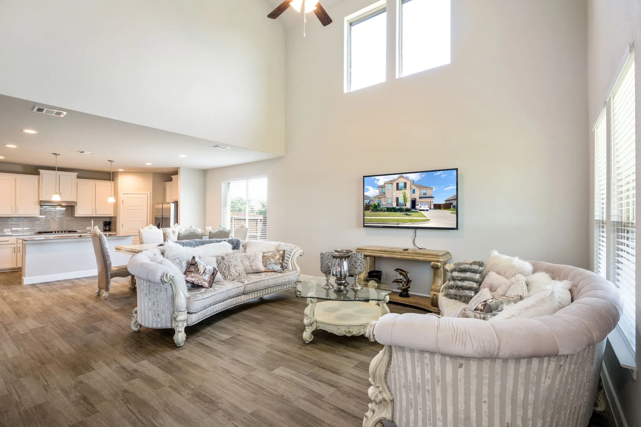 Spacious living area featuring high ceilings, wood-finish flooring, and an open concept layout