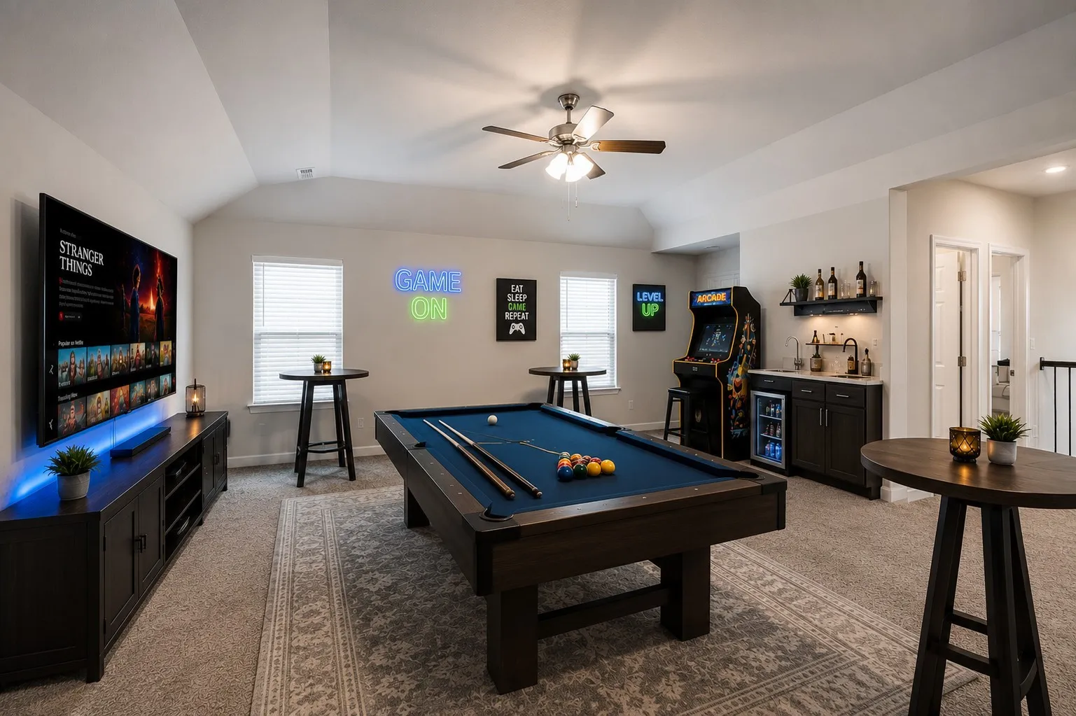 Spacious bonus room featuring vaulted ceilings, a built-in wet bar with a beverage refrigerator, carpeted flooring with an area rug, and two windows with blinds