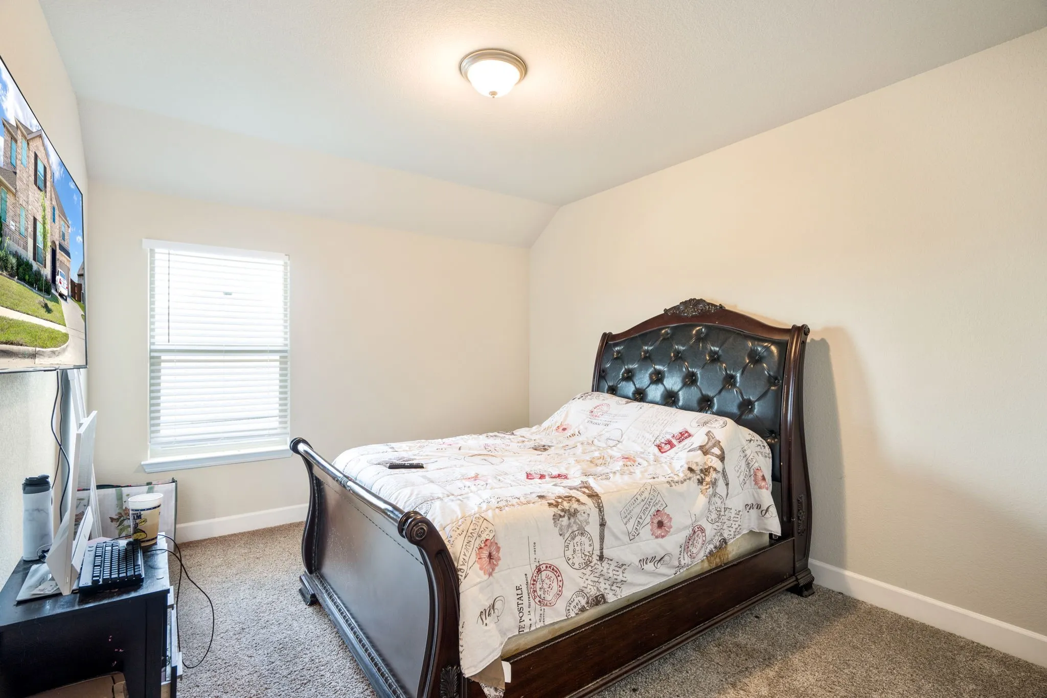 Carpeted room featuring a single window with blinds and a flush mount ceiling light fixture